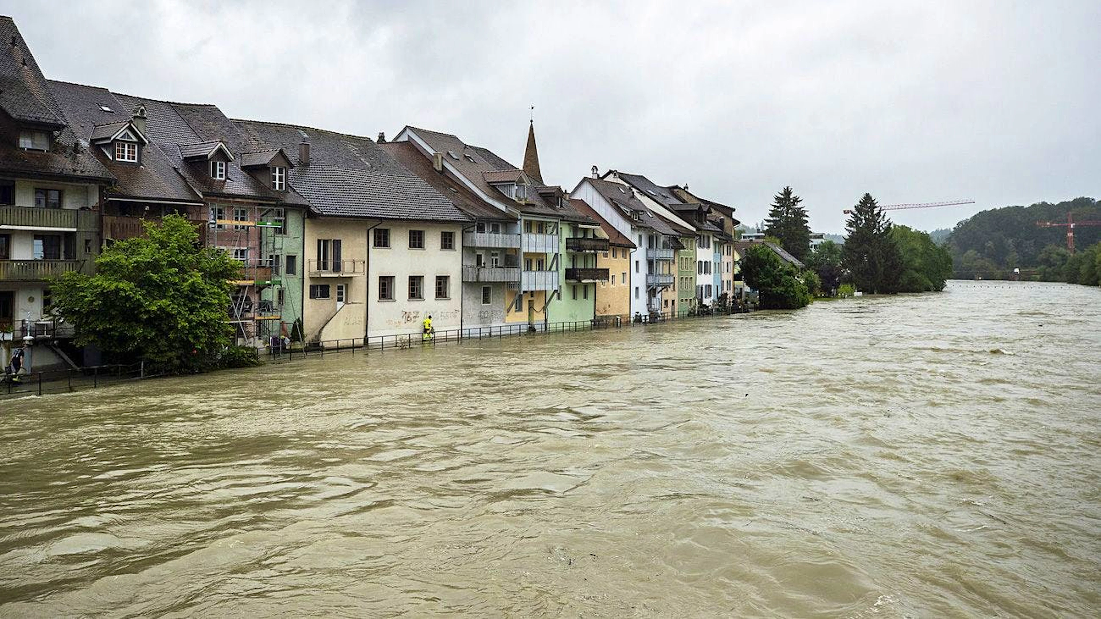 Zivilschutz und Feuerwehr deponieren am 15. Juli Sandsäcke vor Wohnhäusern in Mellingen an der Reuss.