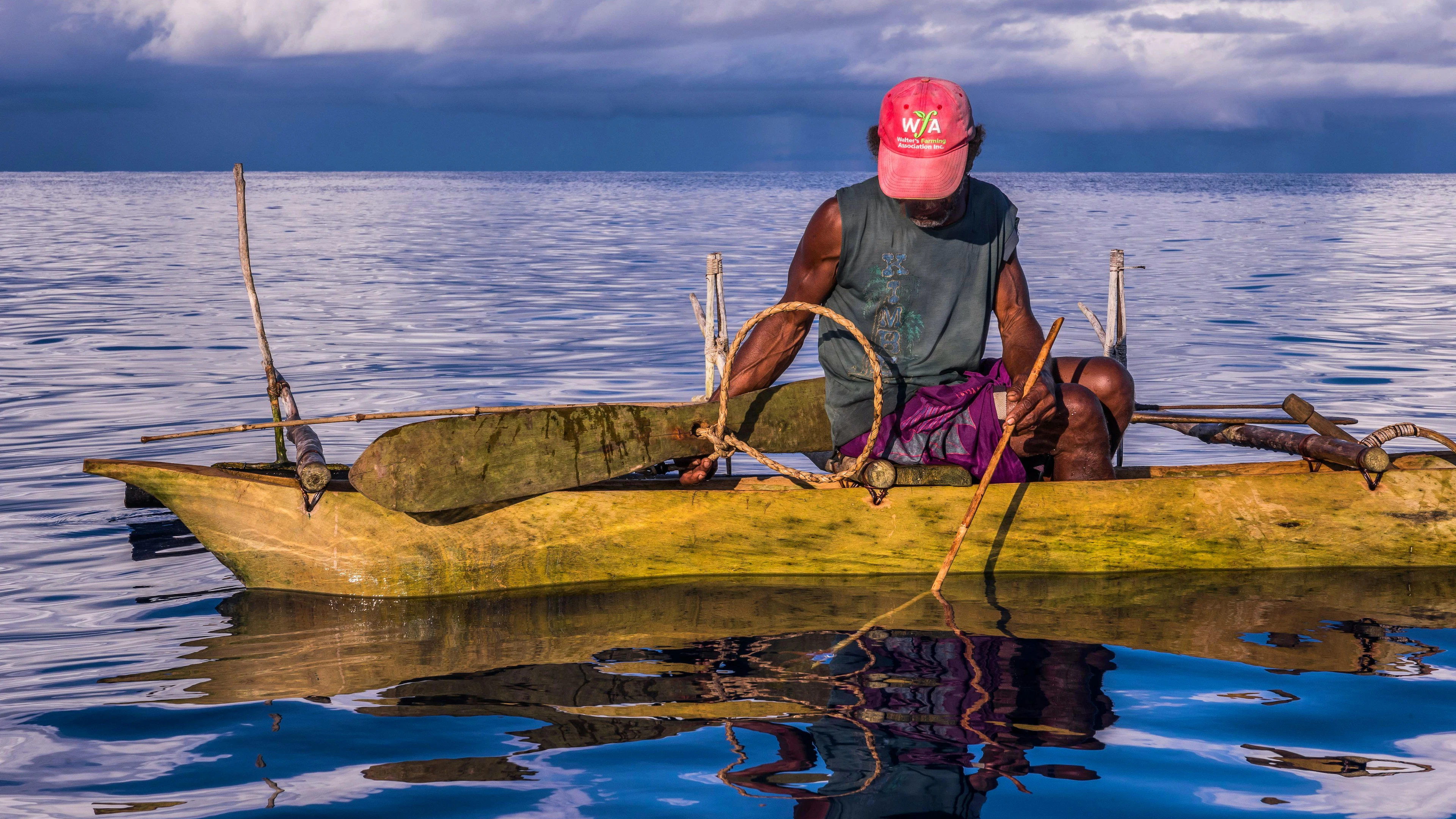 Mit viel Geduld wartet der Haijäger auf seine Beute. Sobald ein Hai nahe vom Kanu ist, hält der Jäger mit einer Hand eine Holzrute mit Fischstücken ins Wasser, mit der anderen balanciert er das Holzlasso auf der Wasseroberfläche. 