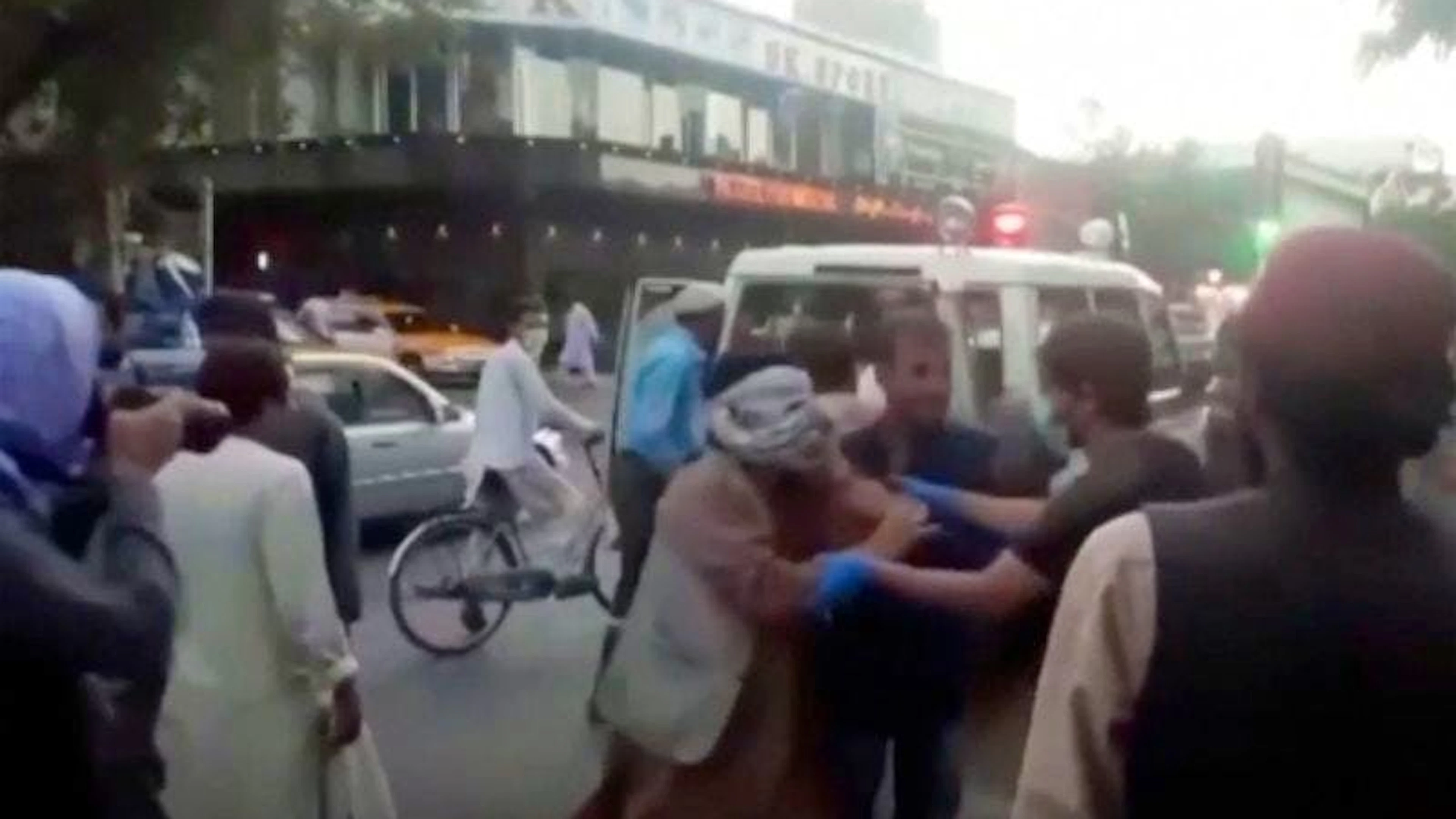 In diesem Bild aus einem Video kümmern sich Menschen um eine verwundete Person in der Nähe des Ortes einer tödlichen Explosion ausserhalb des Flughafens in Kabul.
