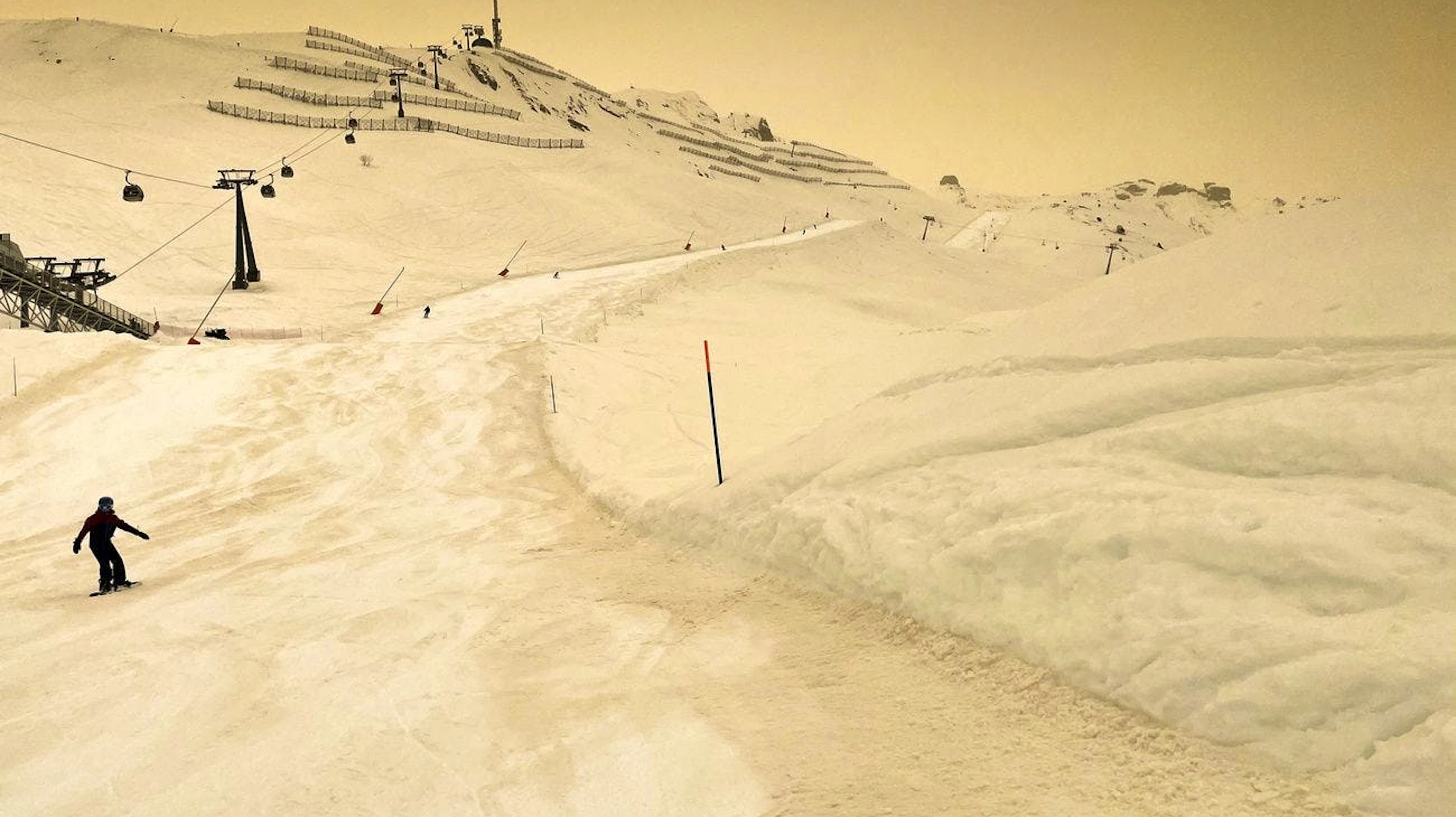 Sahara-Sand färbt Schnee und Himmel orange im Skigebiet Anzère in der Schweiz.