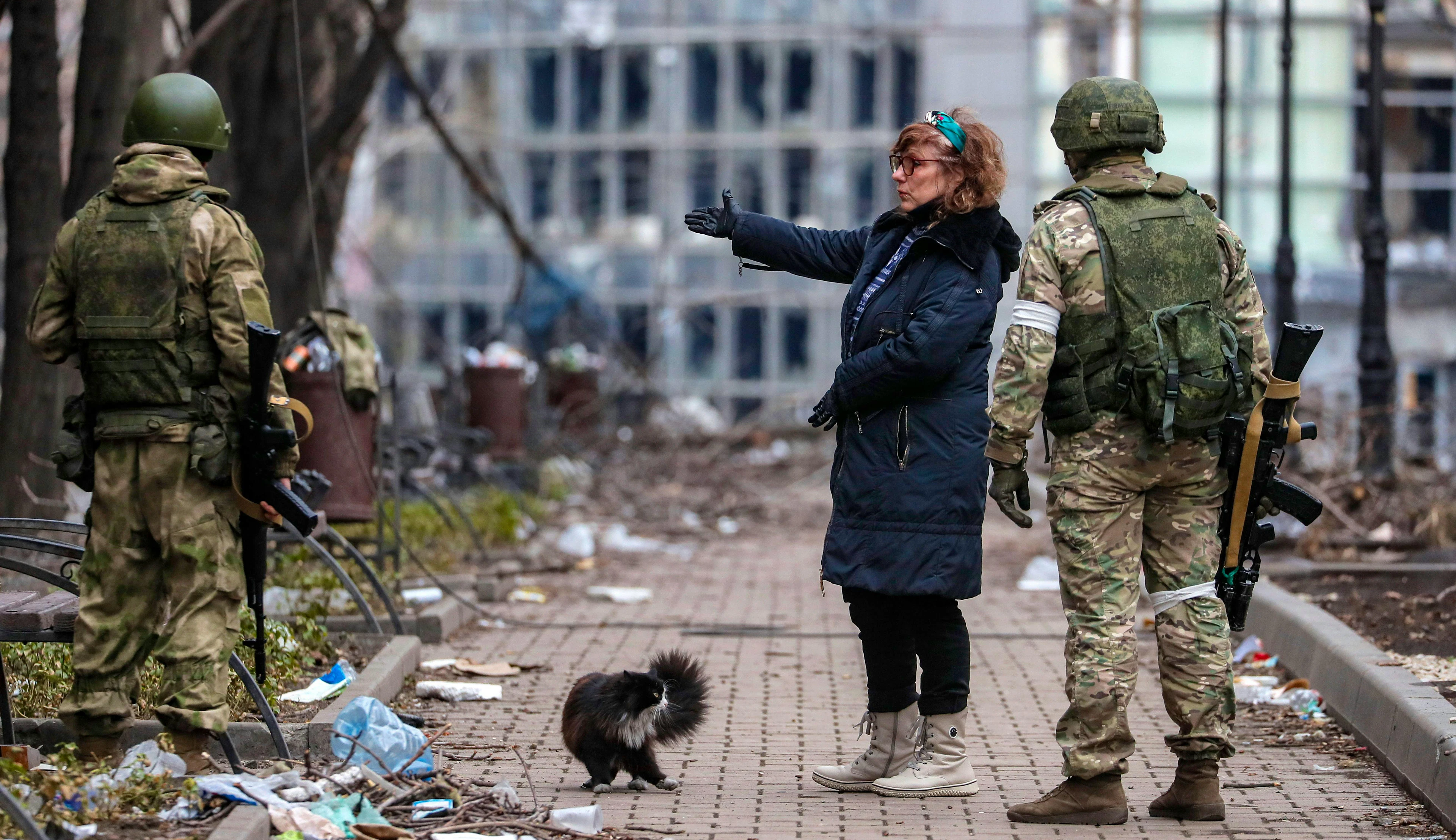 Soldaten am 12. April in Mariupol im Gespräch mit einer Zivilistin: Die russischen Soldaten haben nicht nur physisch mit dem ukrainischen Widerstand zu kämpfen. Auch psychologisch gehen Partisanen in die Offensive. Achtung: Unter den folgenden Propaganda-Plakaten sind auch solche, die grafisch den Tod von Russen darstellen.