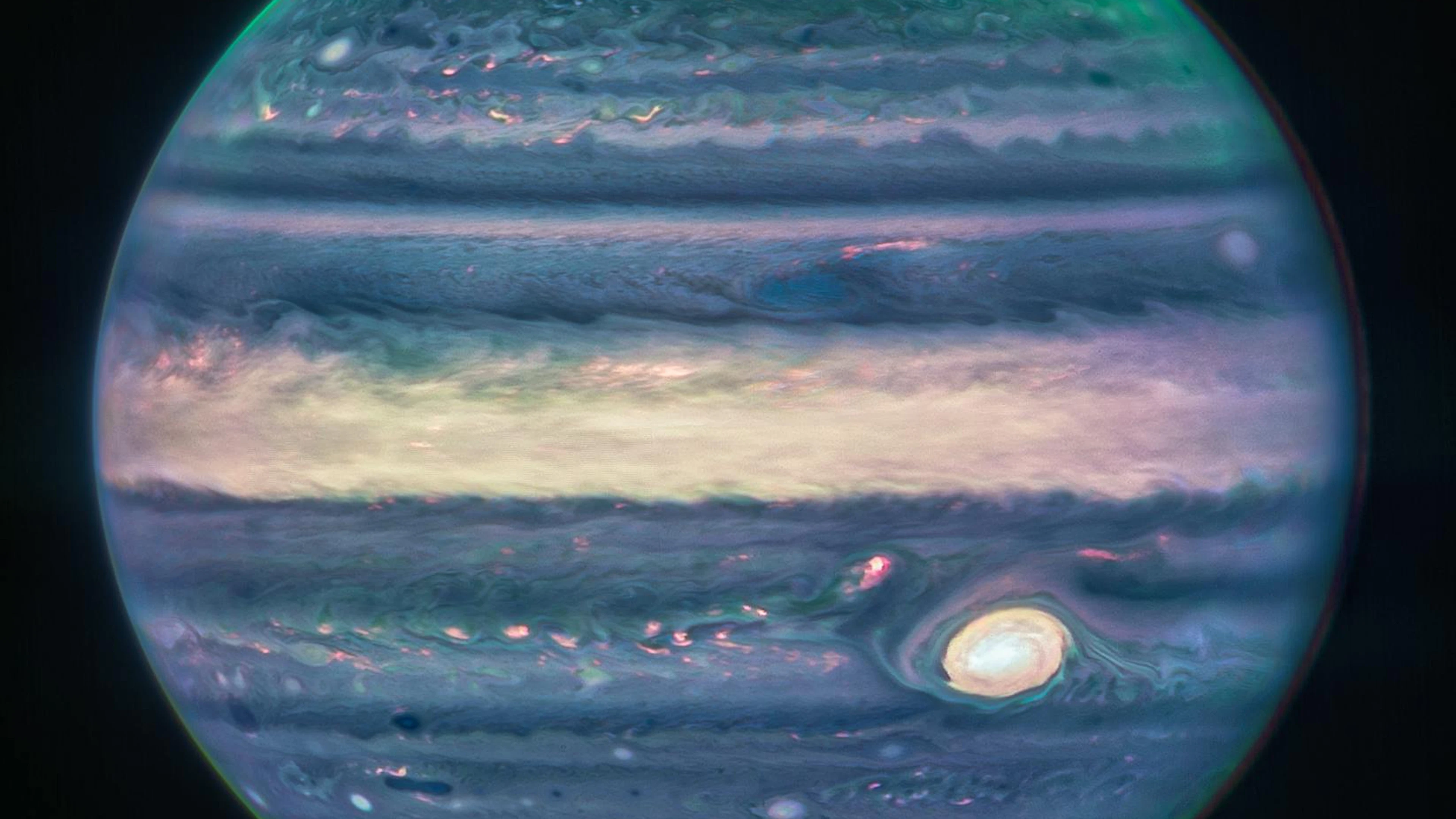 Auf der Oberfläche toben gigantische Stürme: Ein eindrückliches Komposit-Bild vom Jupiter inklusive Polarlichter über den Polen, das die&nbsp;NIRCam-Kamera mit drei Filtern aufgenommen hat.&nbsp;