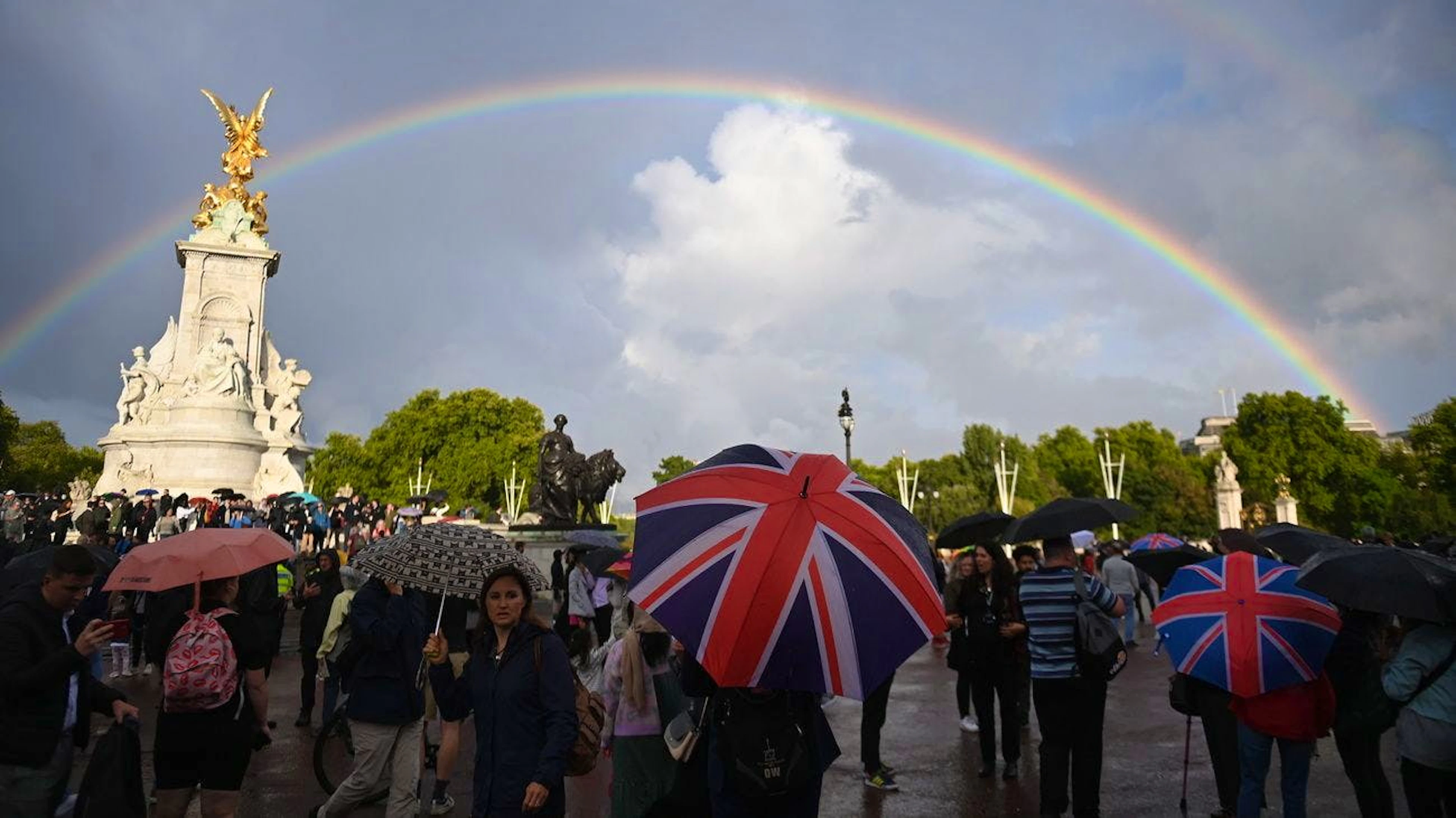 Kurz bevor der Tod der Queen bekannt gegeben wird, lichtet sich der graue Himmel über den Menschen, die sich vor dem Buckingham in London versammelt haben.&nbsp;