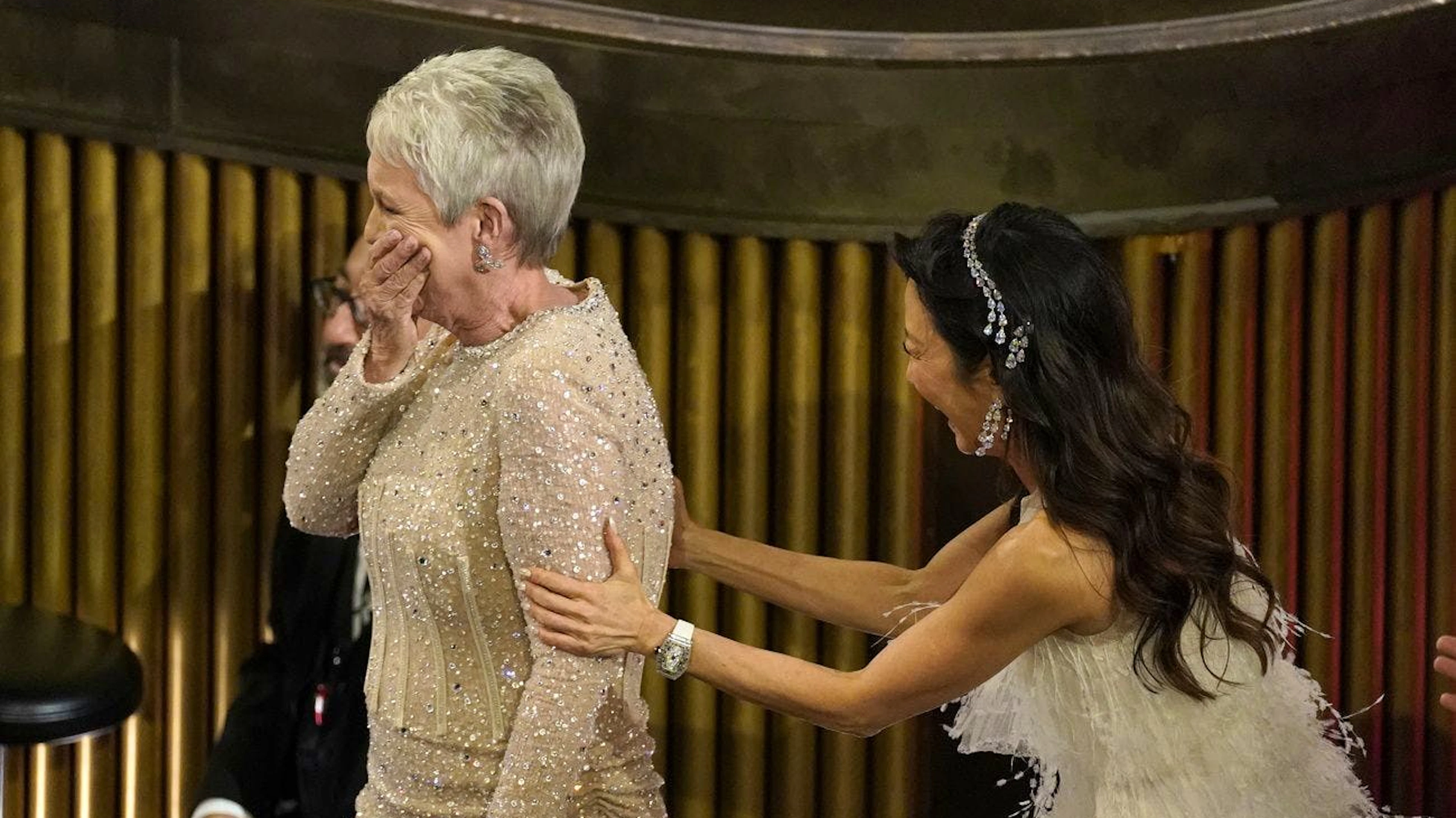 Völlig unerwartet: Der Oscar für die beste Nebendarstellerin geht an die Ikone Jamie Lee Curtis, die ihr Glück nicht fassen kann. Michelle Yeoh gratuliert ihr auf dem Weg zur Bühne, wo sie ihre goldene Statuette entgegen nimmt.