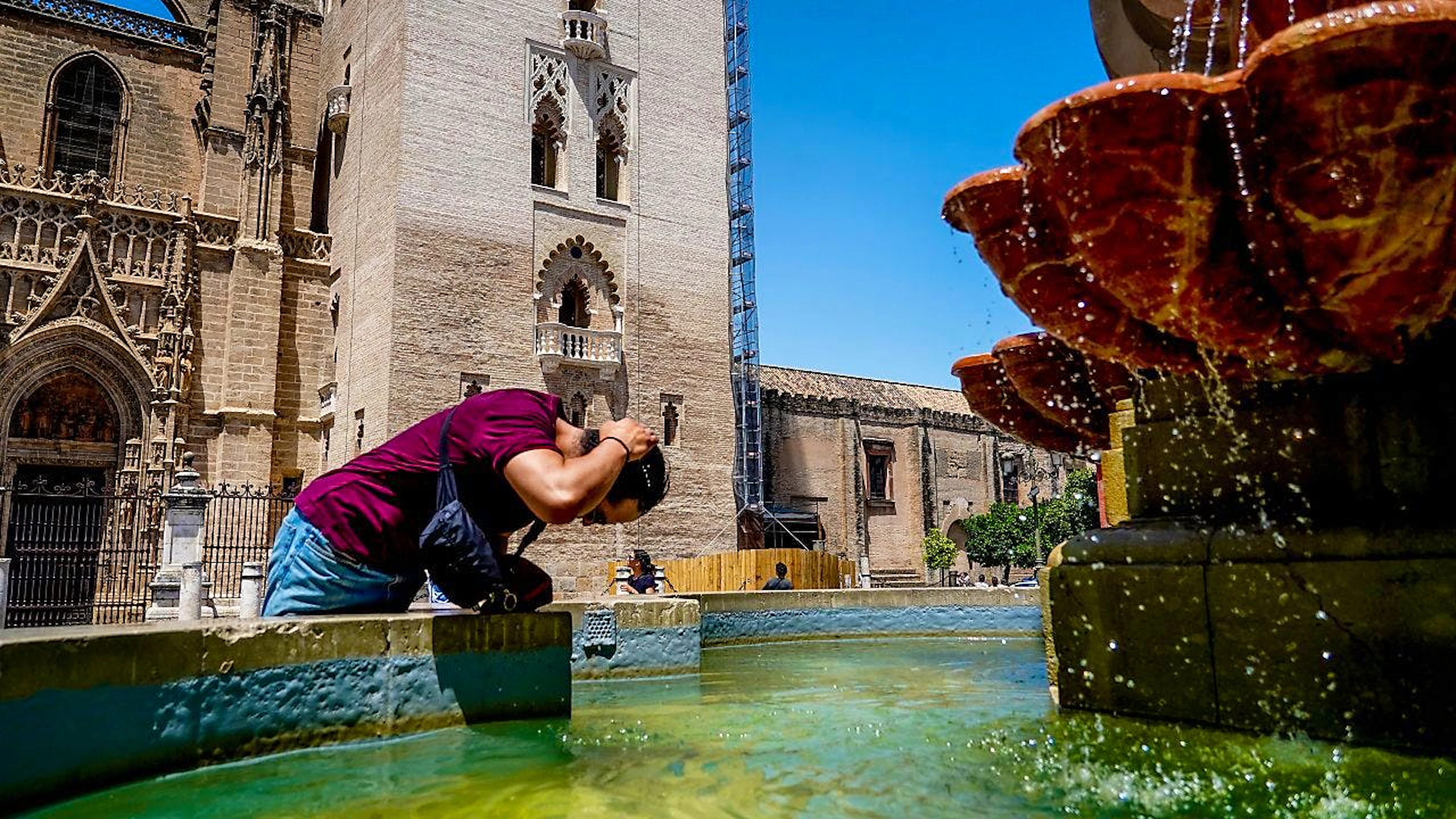 In Spanien gilt im Juli verbreitet Hitze-Alarmstufe Rot: Ein Tourist kühlt sich in einem Brunnen auf der Plaza Virgen de los Reyes in Sevilla.&nbsp;