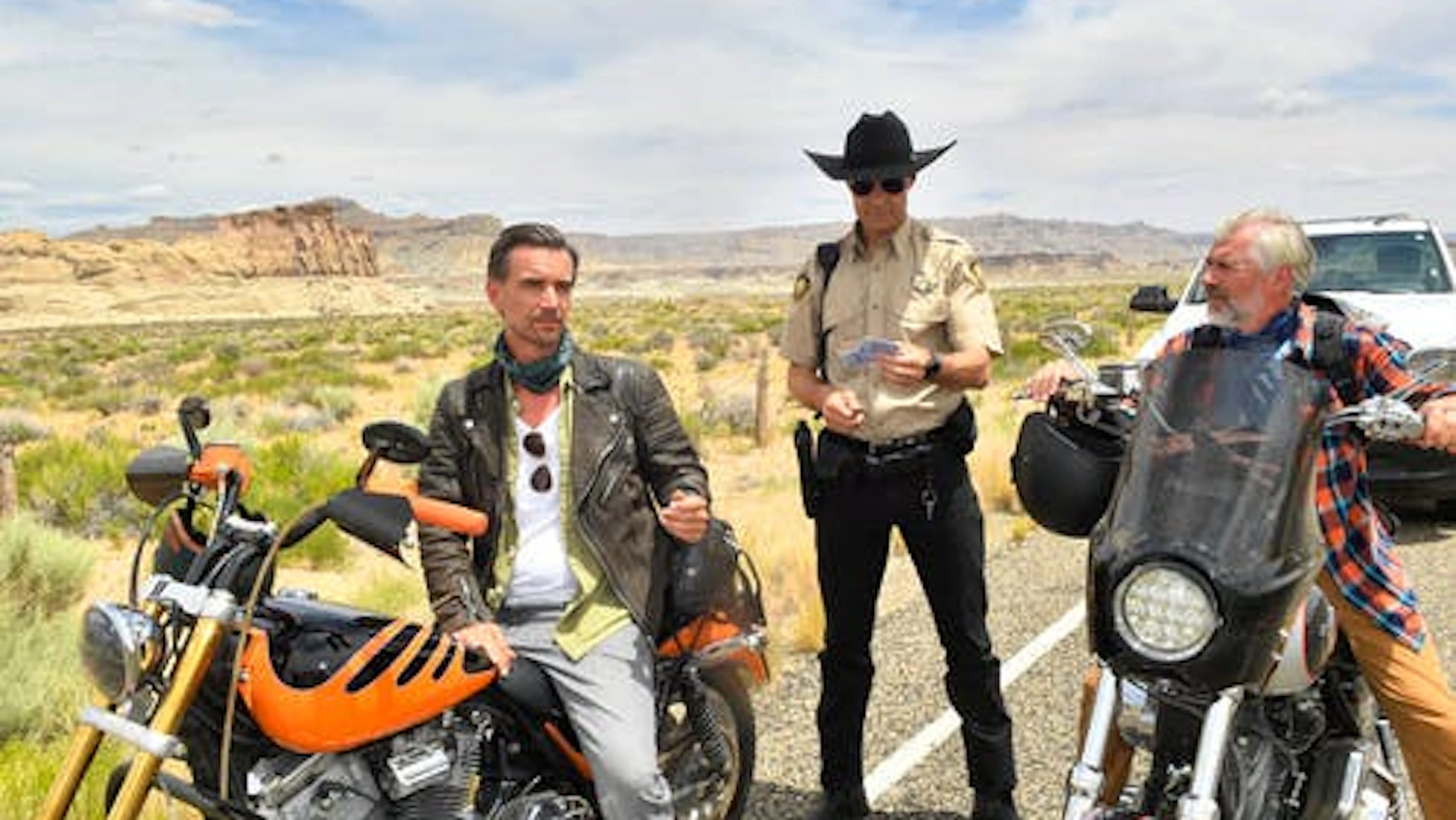 Max Parger (Florian Silbereisen, l.) und Martin Grimm (Daniel Morgenroth, r.) haben ein Problem: Sheriff Steve McCrown (Kai Pflaume) erkennt ihre Führerscheine nicht an. Aus dem Film «Das Traumschiff: Utah». 
