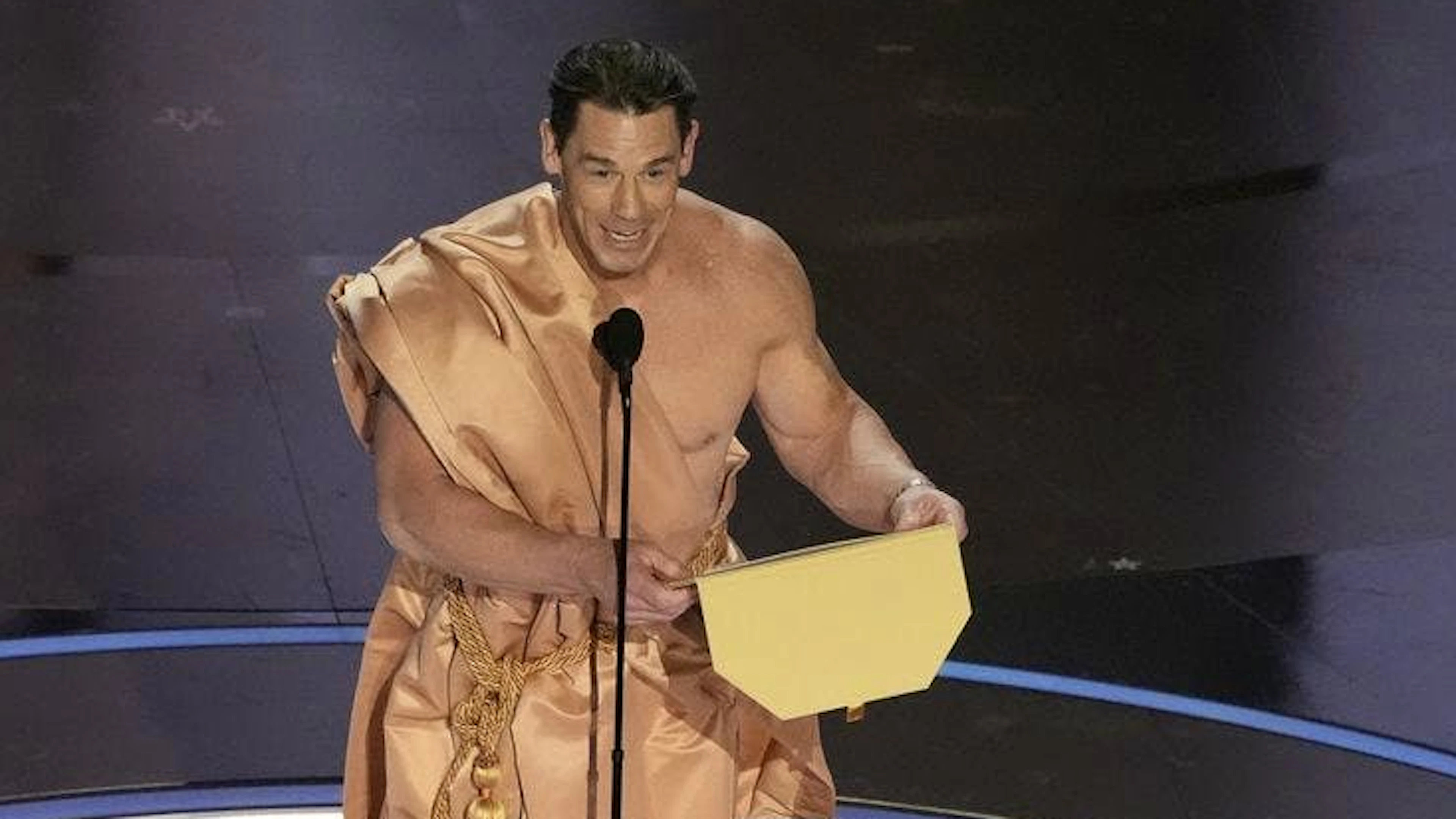 John Cena wirft einen Vorhang über, nachdem er nur mit Couvert nackt auf der Bühne auftaucht. Er vergab den Oscar für das «Beste Kostümdesign» an «Poor Things».