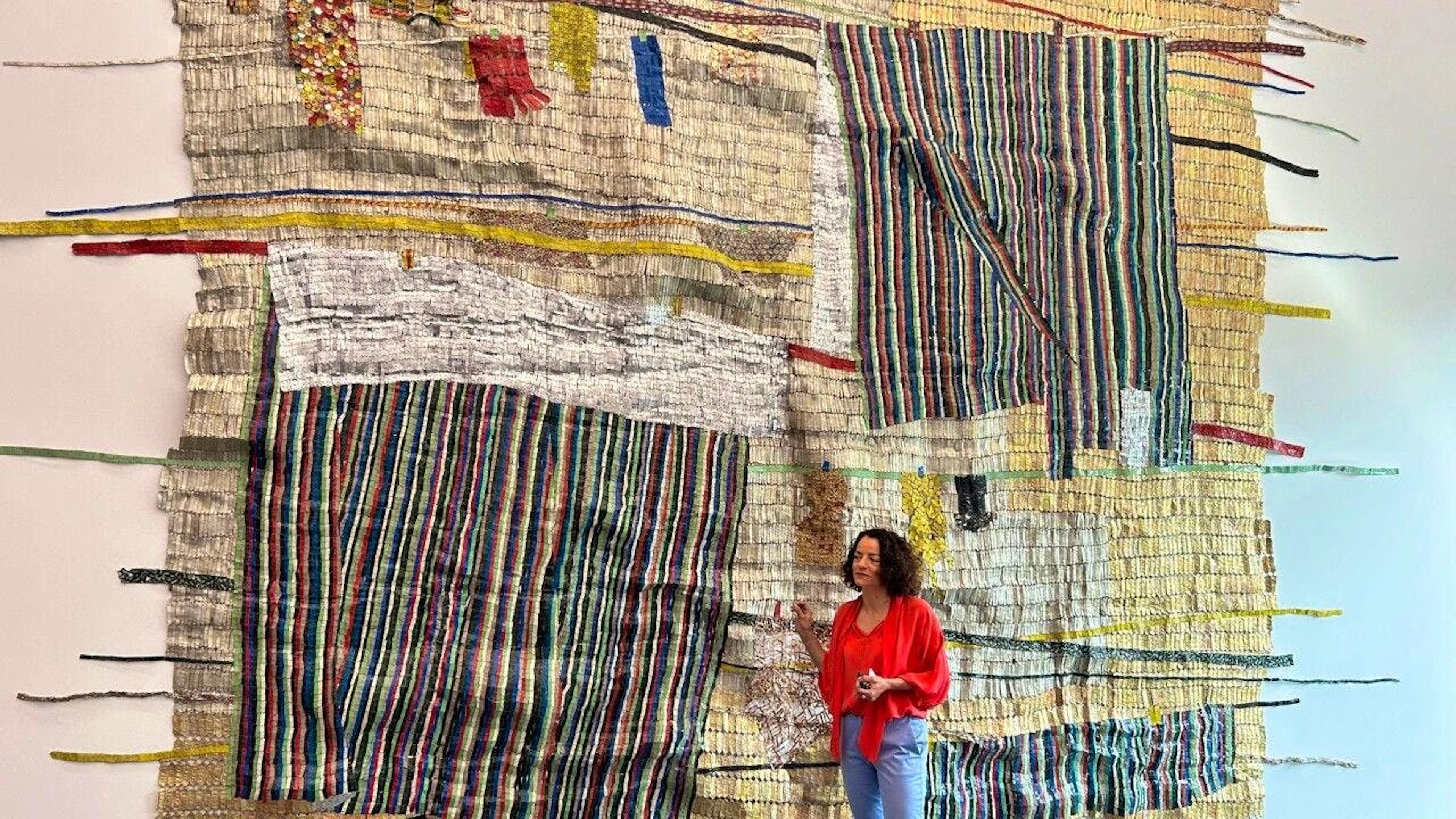 Direktorin Ines Goldbach vor der monumentalen Tapisserie "Drying Line" von El Anatsui in der Eröffnungsausstellung des neuen Kunsthauses Baselland.