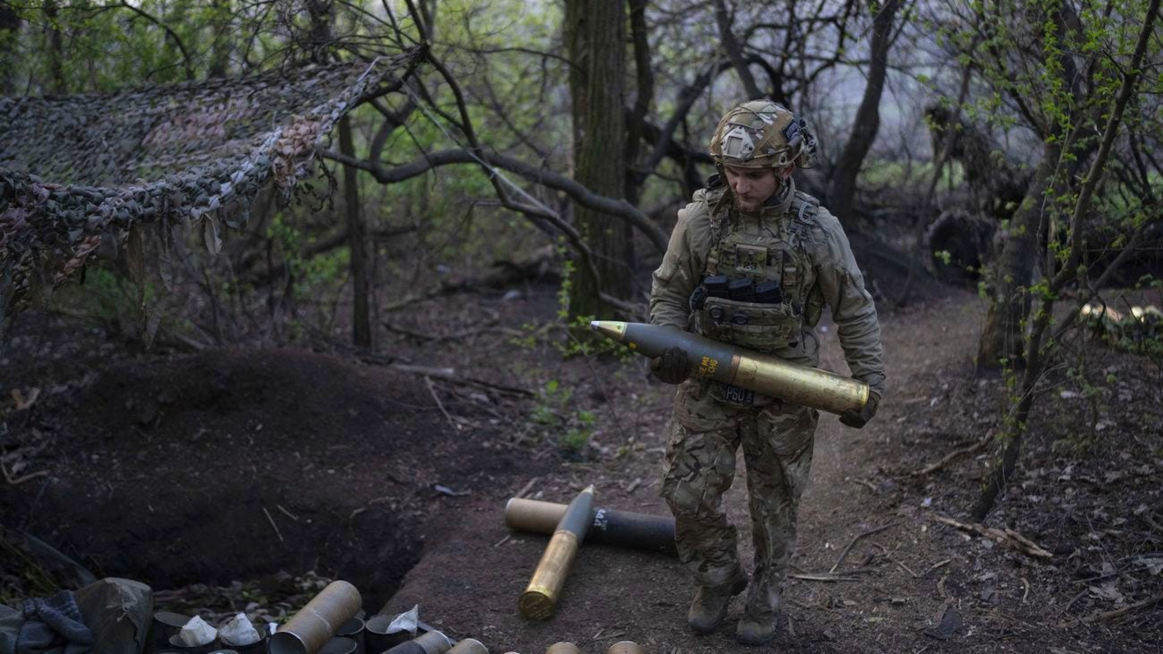 Un militare ucraino della brigata Azov conosciuto con il nominativo Ray, 20 anni, trasporta un proiettile per l'obice OTO Melara Mod 56 in prima linea in direzione di Kreminna.