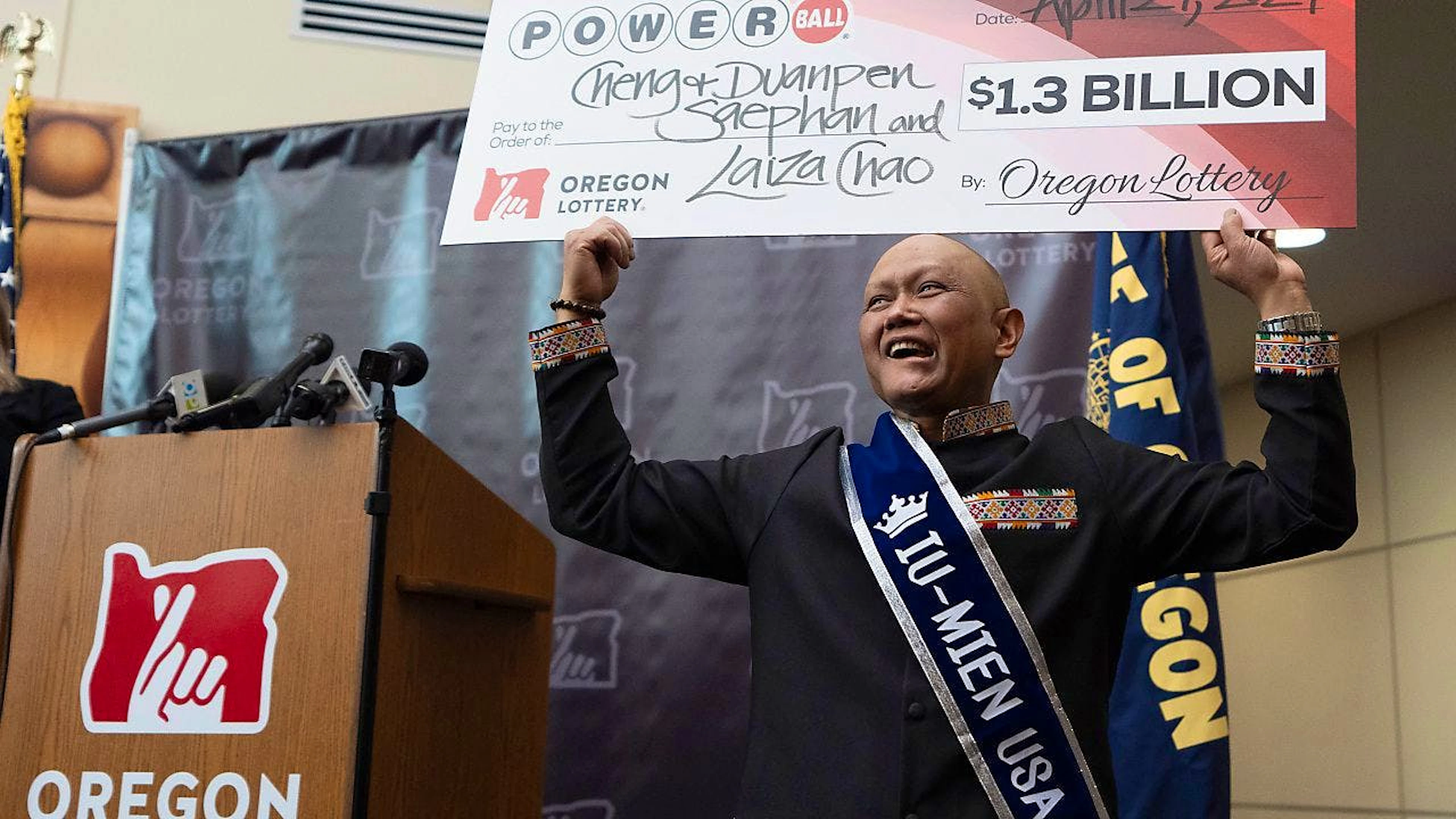 Cheng Saephan hält auf einer Pressekonferenz in der Lotteriezentrale von Oregon in Salem einen übergroßen Scheck in die Höhe. Foto: Jenny Kane/AP/dpa