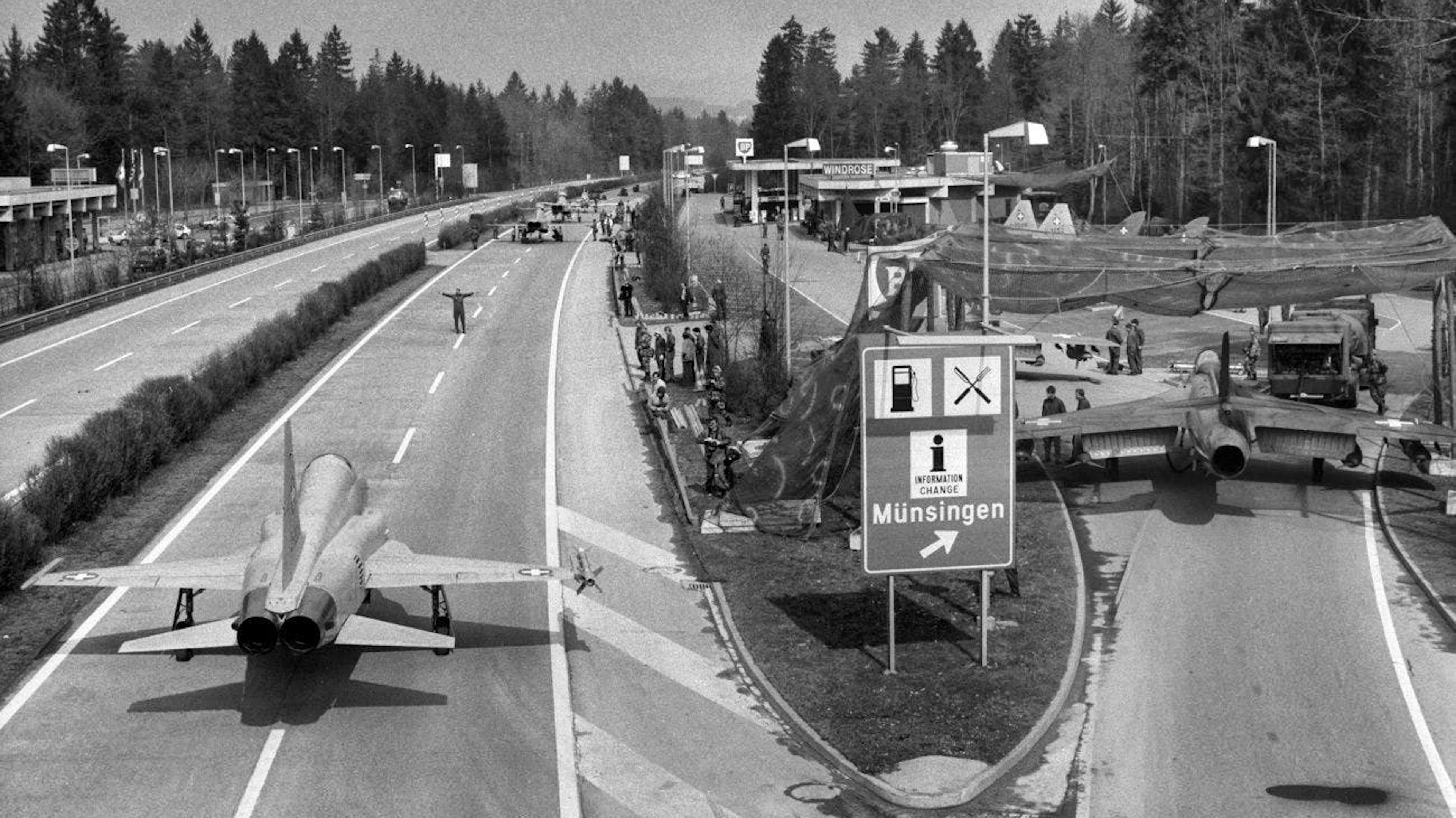 A sinistra l'F-5 Tiger, a destra un Hawker Hunter all'ingresso di un'area di servizio autostradale.