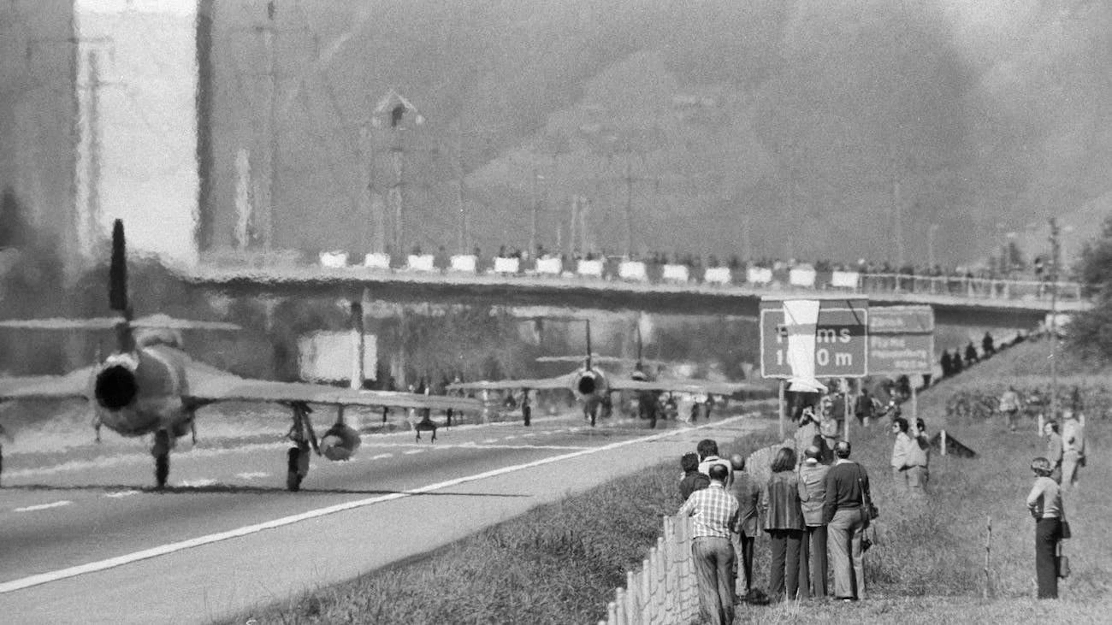 Gli spettatori mostrano un vivo interesse per la manovra autostradale.