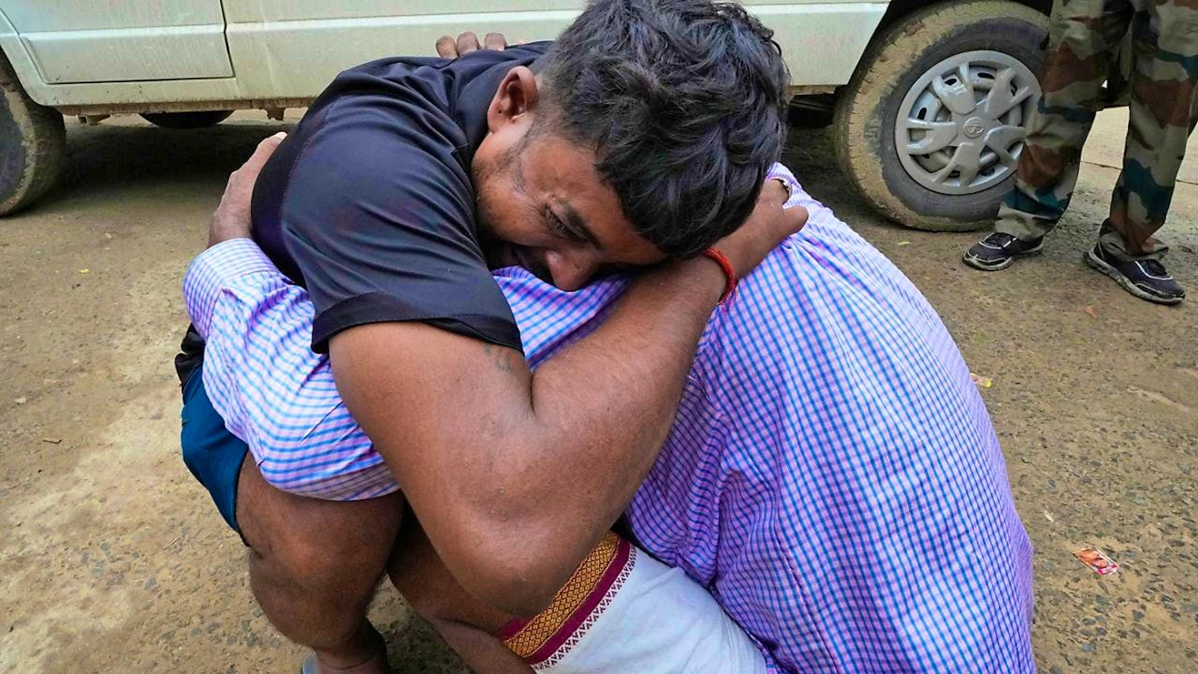 A man cries and hugs the father-in-law of his 37-year-old sister Ruby, who was the victim of a stampede in India. Photo: Rajesh Kumar Singh/AP/dpa