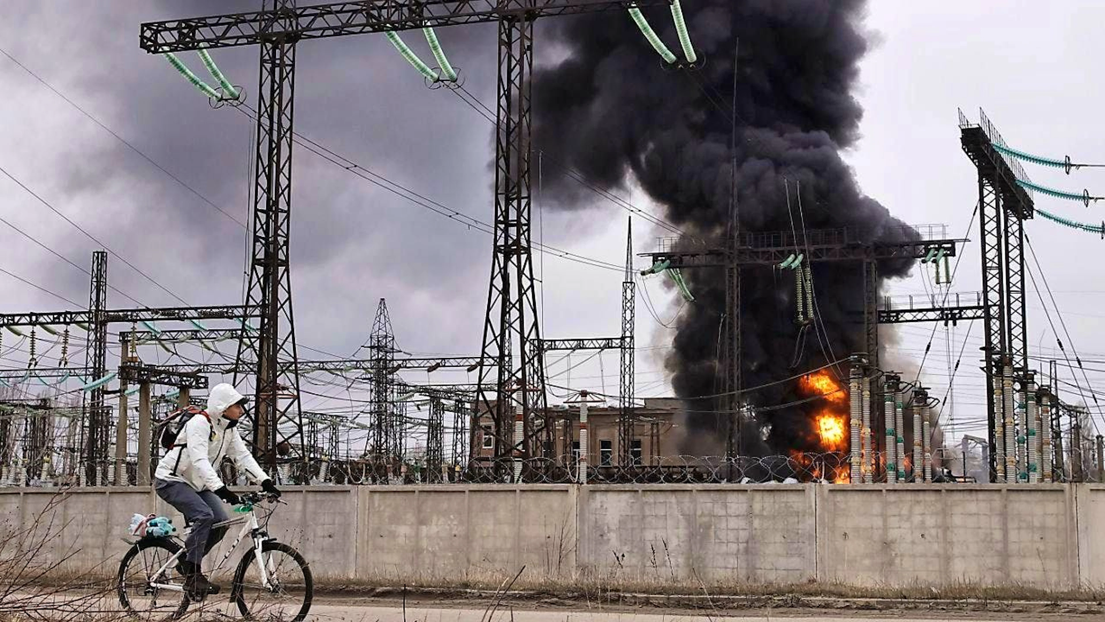ARCHIVE - A man cycles past a power station in Kharkiv after a Russian attack. Photo: Yevhen Titov/AP/dpa