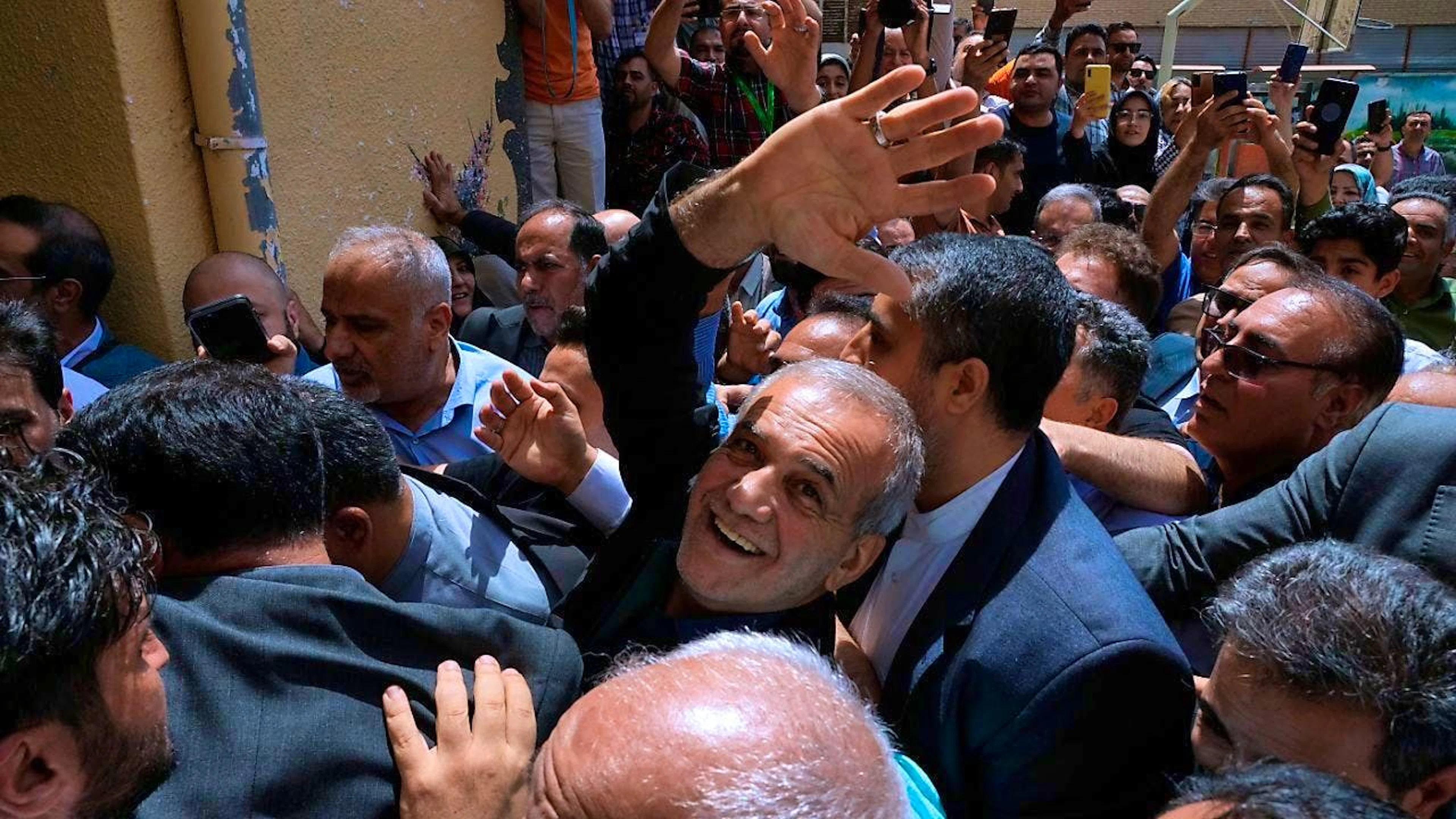 dpatopbilder - The reform candidate for the Iranian presidential elections, Massud Peseschkian, waves in front of a polling station near Tehran. Photo: Vahid Salemi/AP