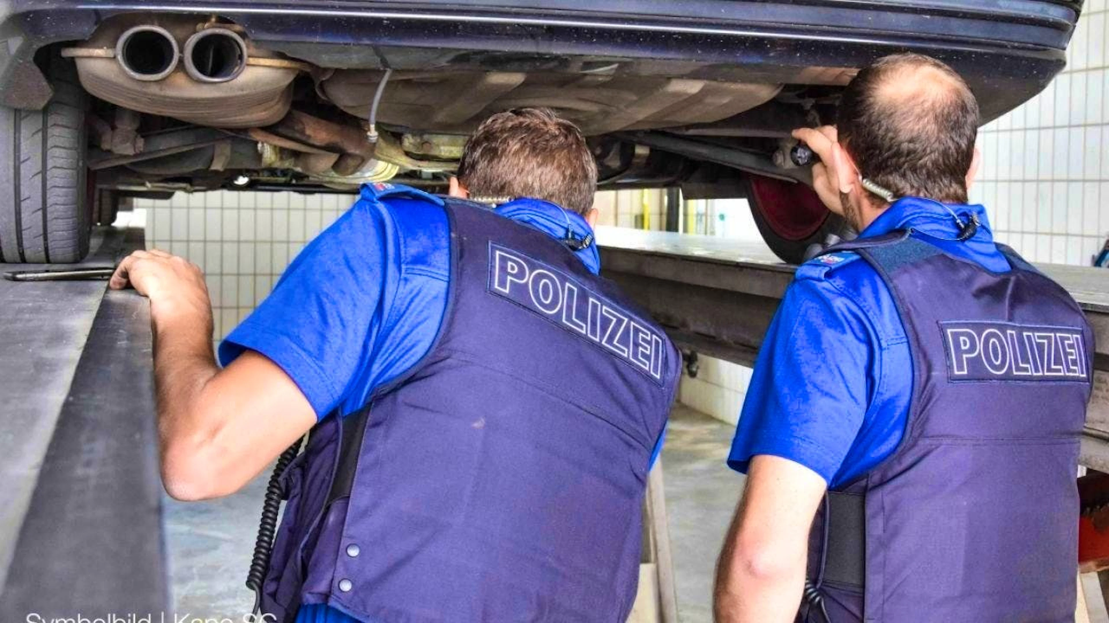 Police specialists inspecting a vehicle.