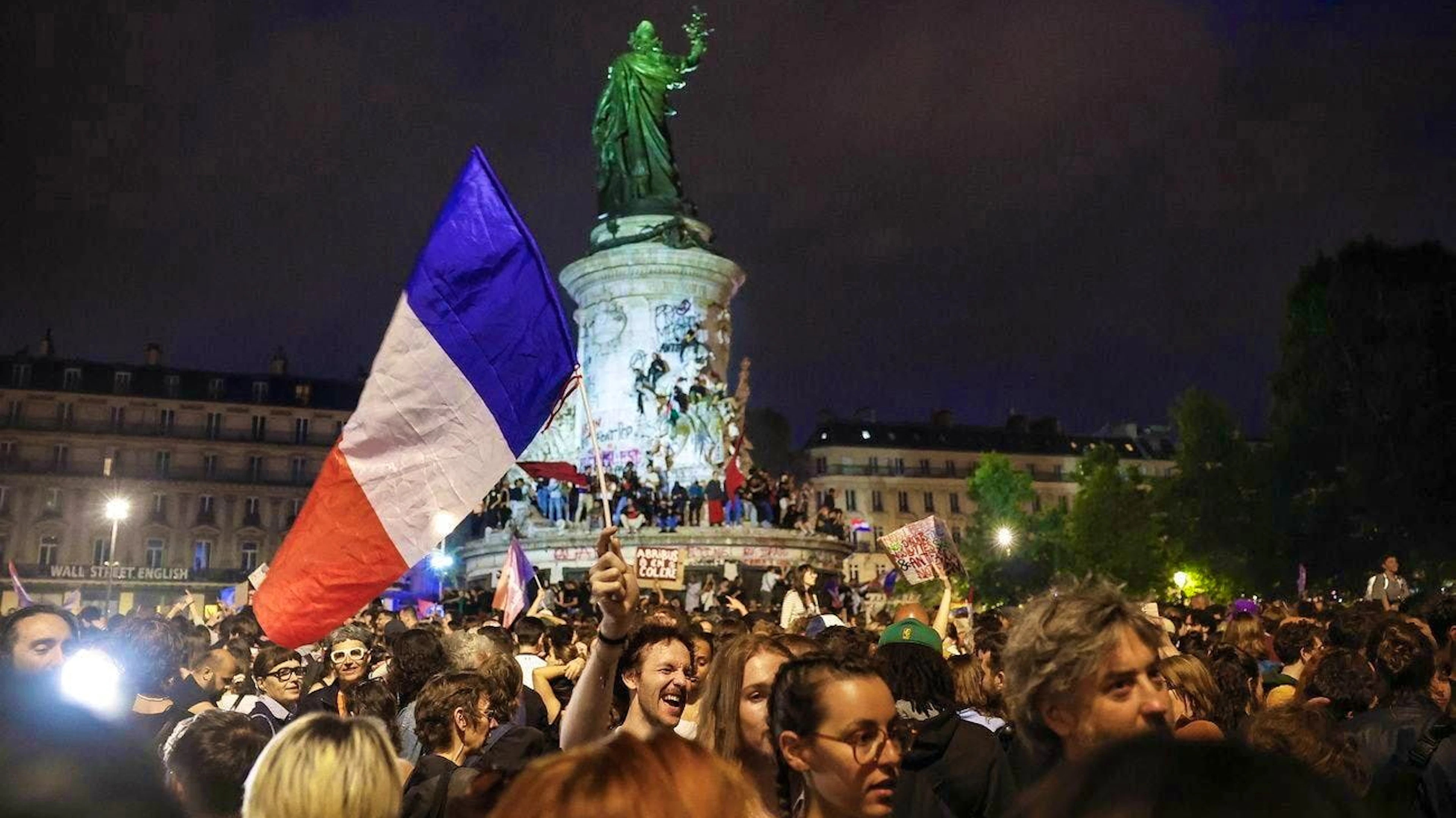 People in Paris celebrate the victory of the left-wing alliance.