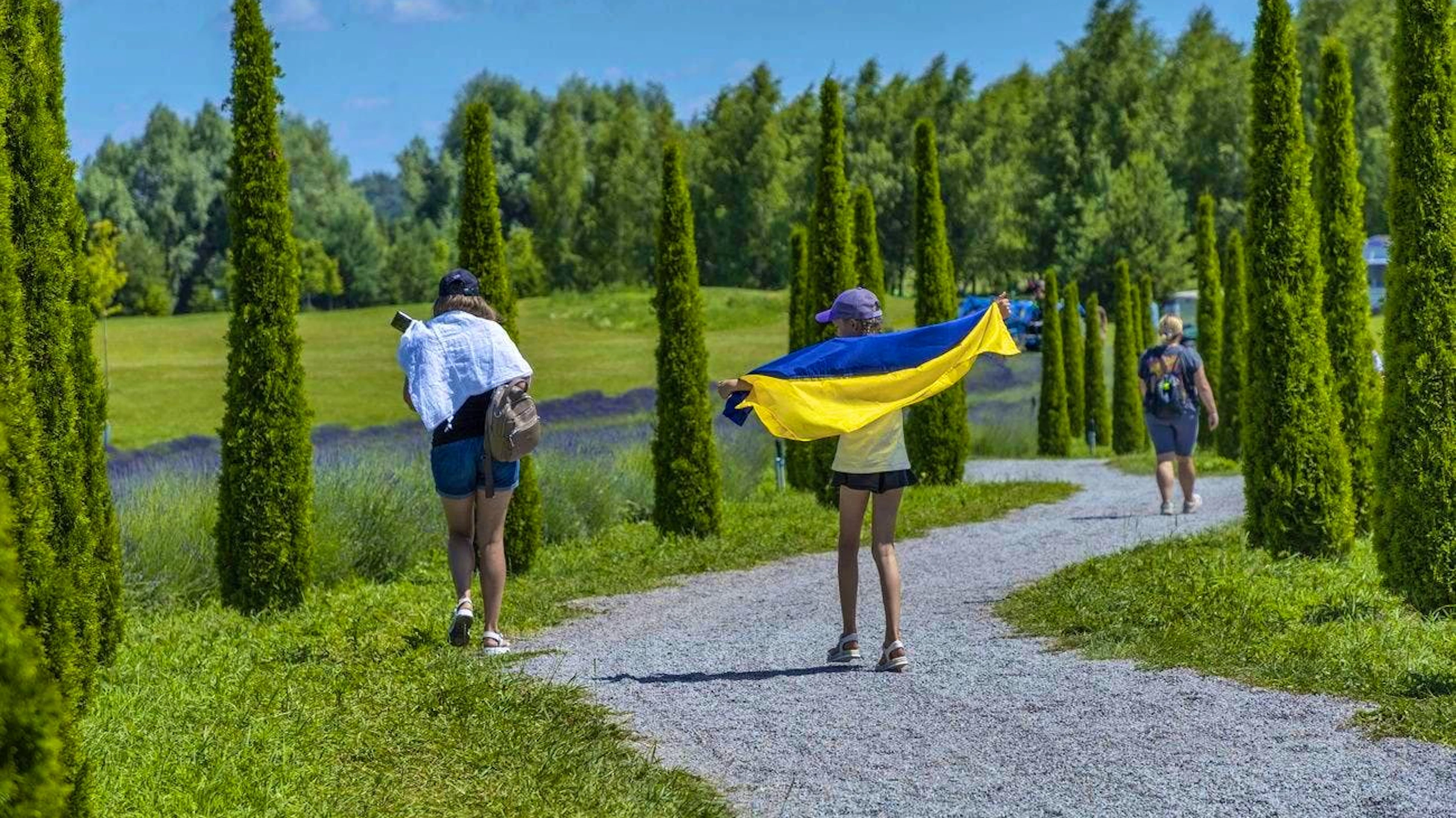 A girl uses a flag to protect herself from the sun: Dobro Park is a 150-hectare garden that was affected by the war and has been restored.