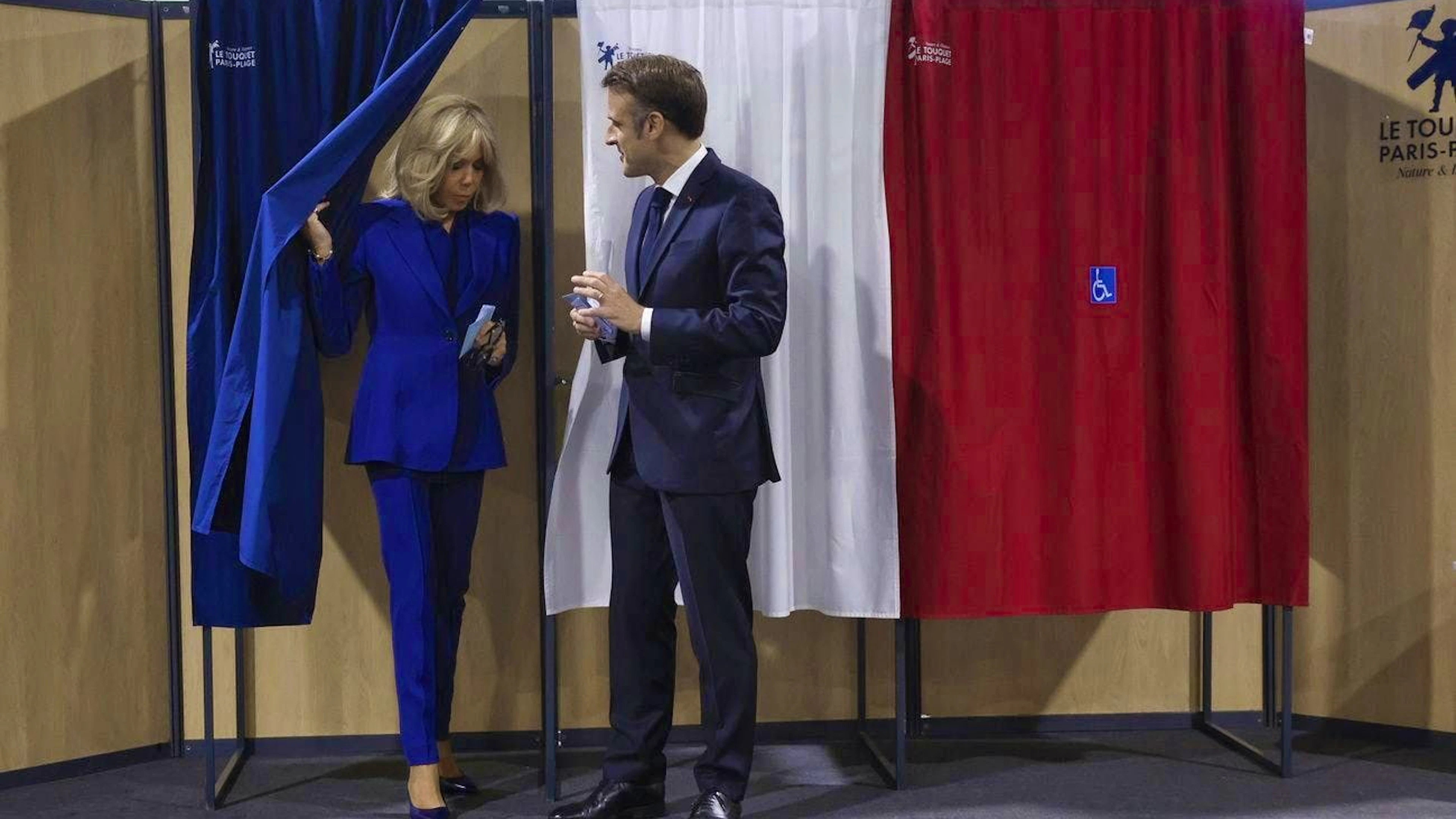 French President Emmanuel Macron and his wife Brigitte Macron leave the voting booth before casting their votes for the second round of the parliamentary elections in Le Touquet-Paris-Plage in northern France.