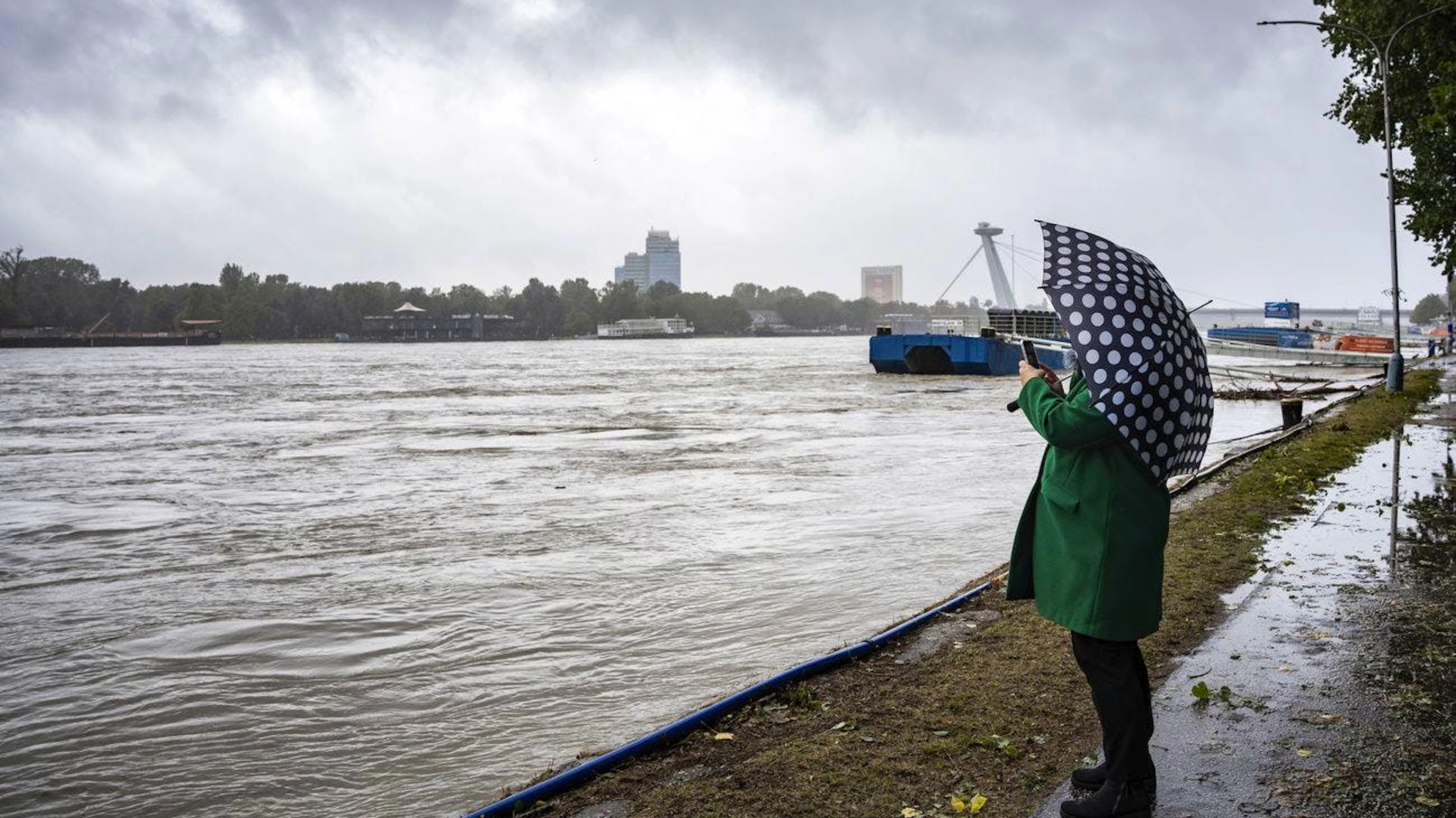Una donna fotografa gli alti livelli del fiume Danubio