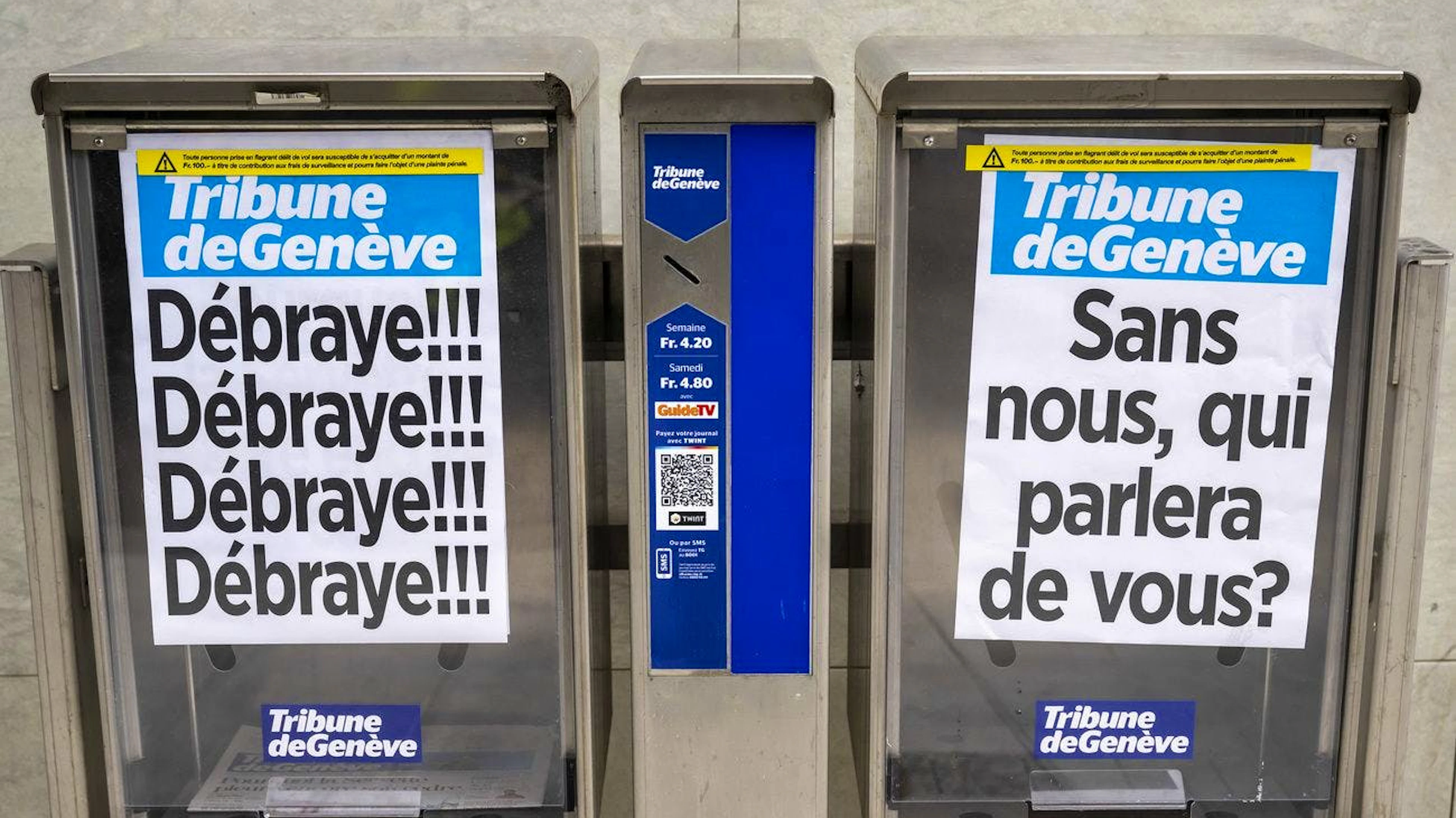 Deux cassettes a journaux avec leurs manchettes sont photographiées pendant que les journalistes et des employés de la Tribune de Genève (TDG), quotidien appartenant au groupe de presse zurichois Tamedia, débrayent et manifestent pour protester en réponse au silence de leur direction suite a plusieurs interpellations, le jeudi 12 septembre 2024 à Genève. 