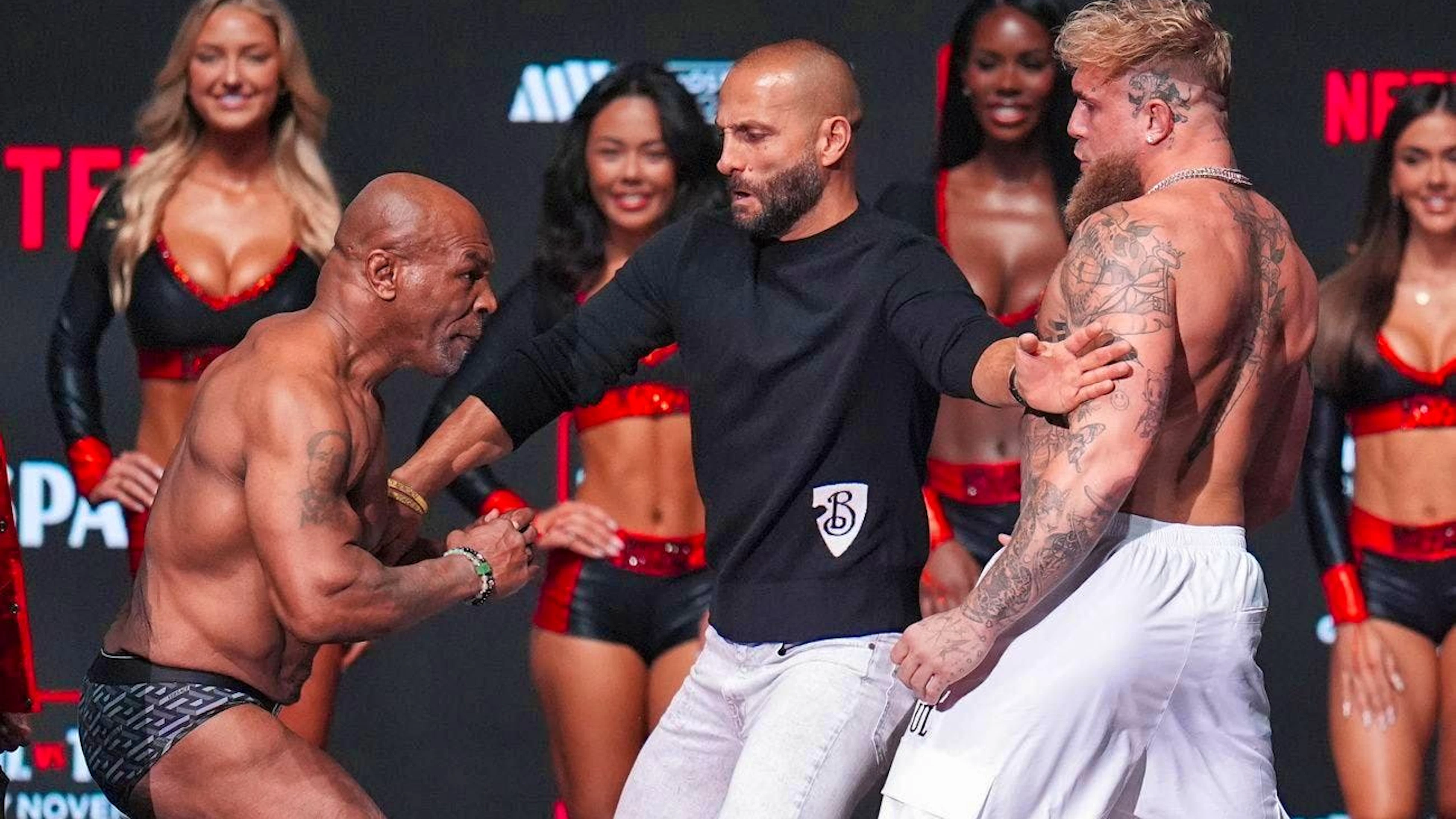Promoter Nakisa Bidarian (center) bravely stands between the two brawlers and prevents an irregular pre-fight.
