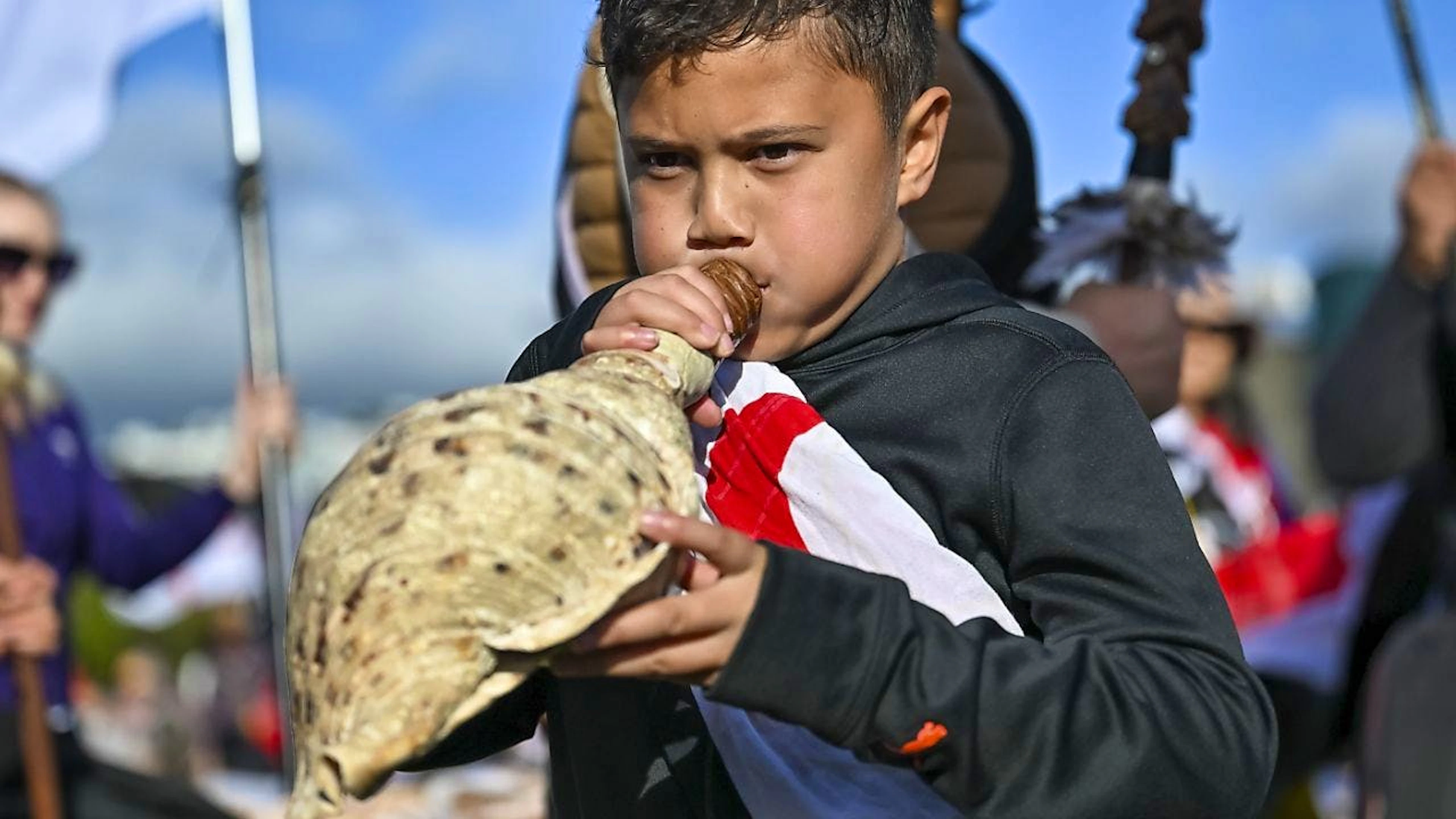 Un enfant souffle dans une conque en marge d'une manifestation pour défendre les droits des maoris à Wellington en Nouvelle-Zélande mardi.