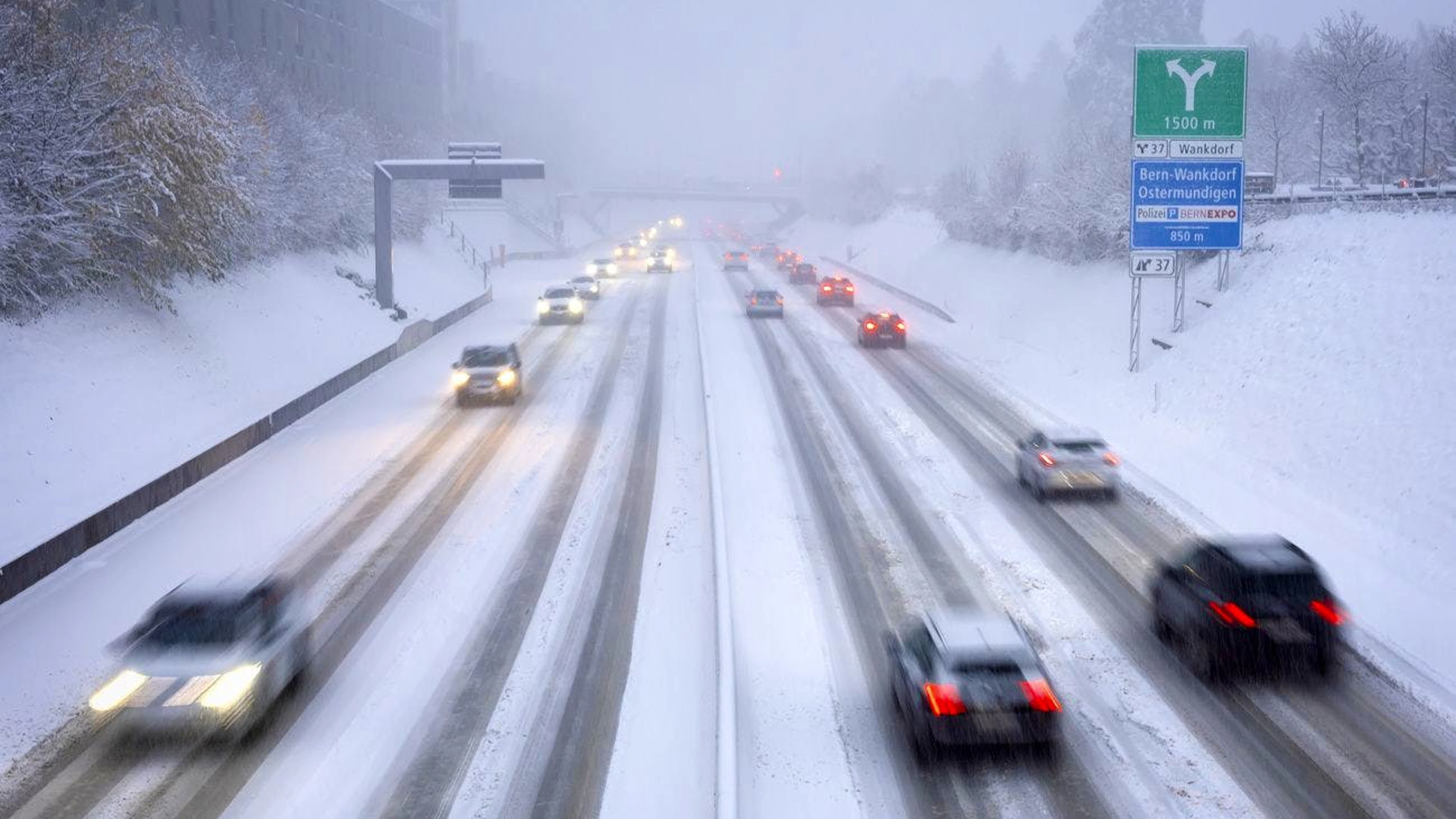 Des voitures roulent sur l'autoroute recouverte de neige, le jeudi 21 novembre 2024 à Berne. (KEYSTONE/Peter Klaunzer)