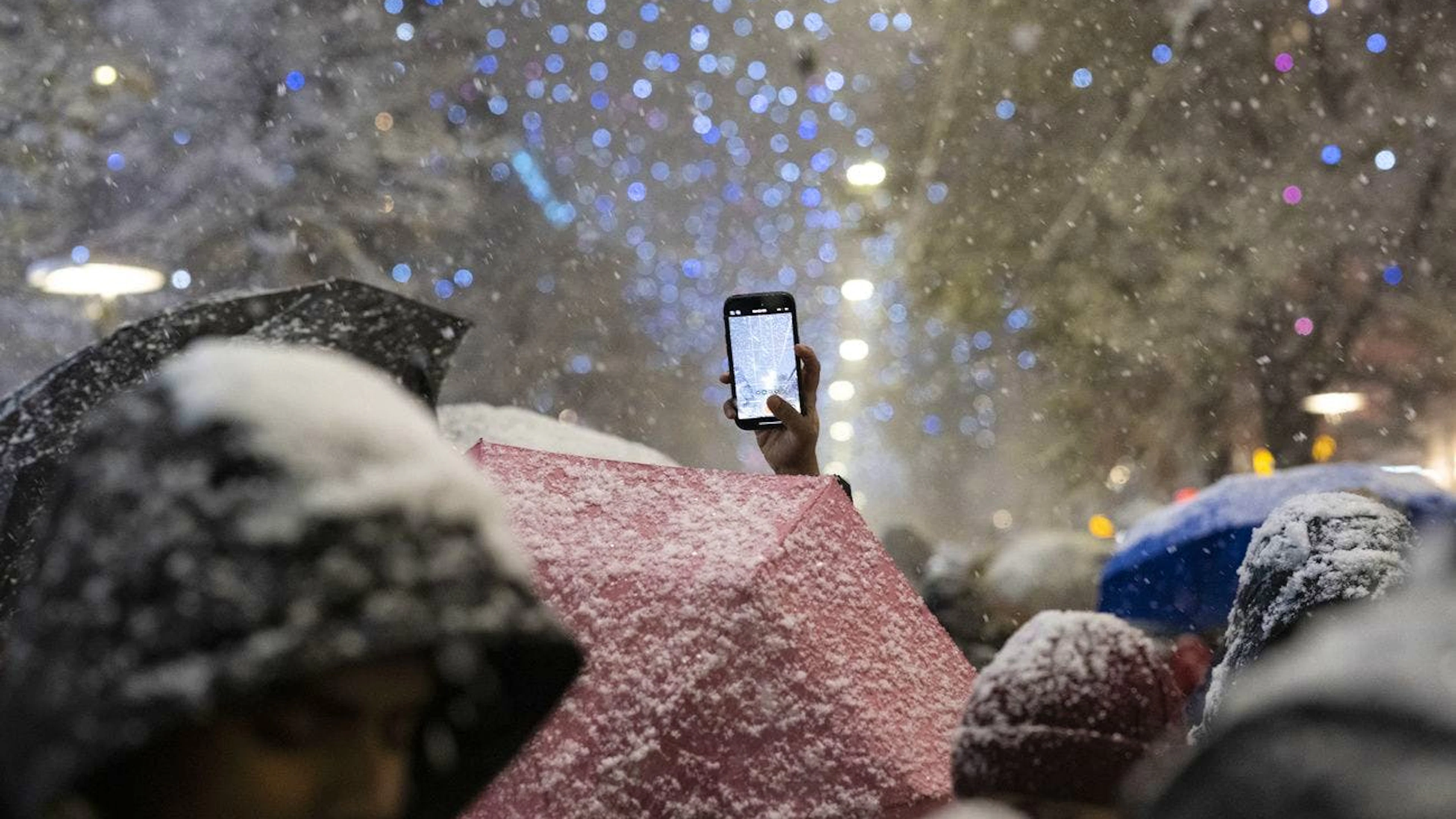 Des personnes photographient les illuminations de Noël « Lucy » à la Bahnhofstrasse, prises le jeudi 21 novembre 2024 à Zurich. (KEYSTONE/Ennio Leanza)