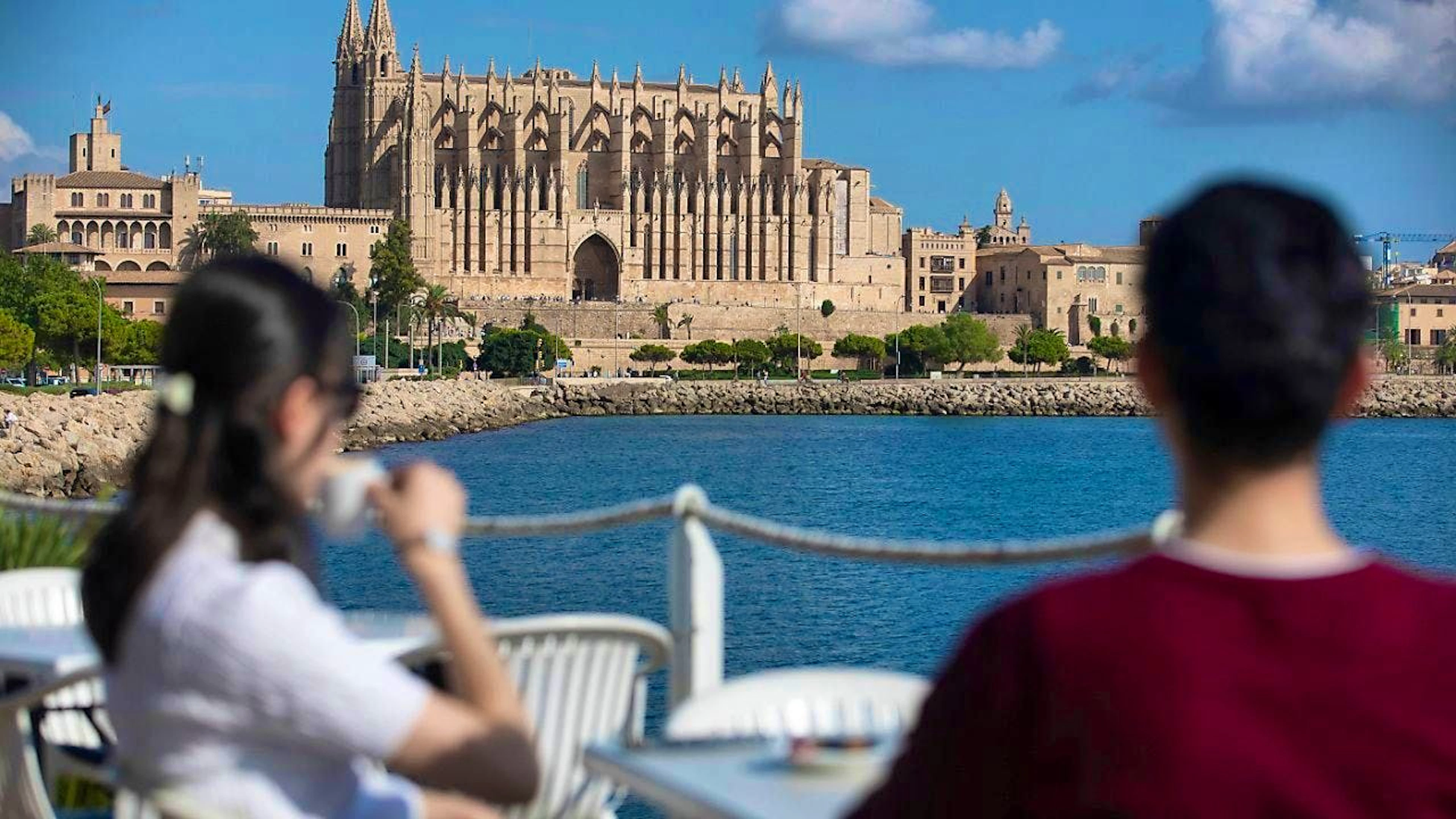ARCHIVE - On a sunny day in Palma, two people have a drink on the terrace of a restaurant opposite Palma Cathedral. Photo: Clara Margais/dpa
