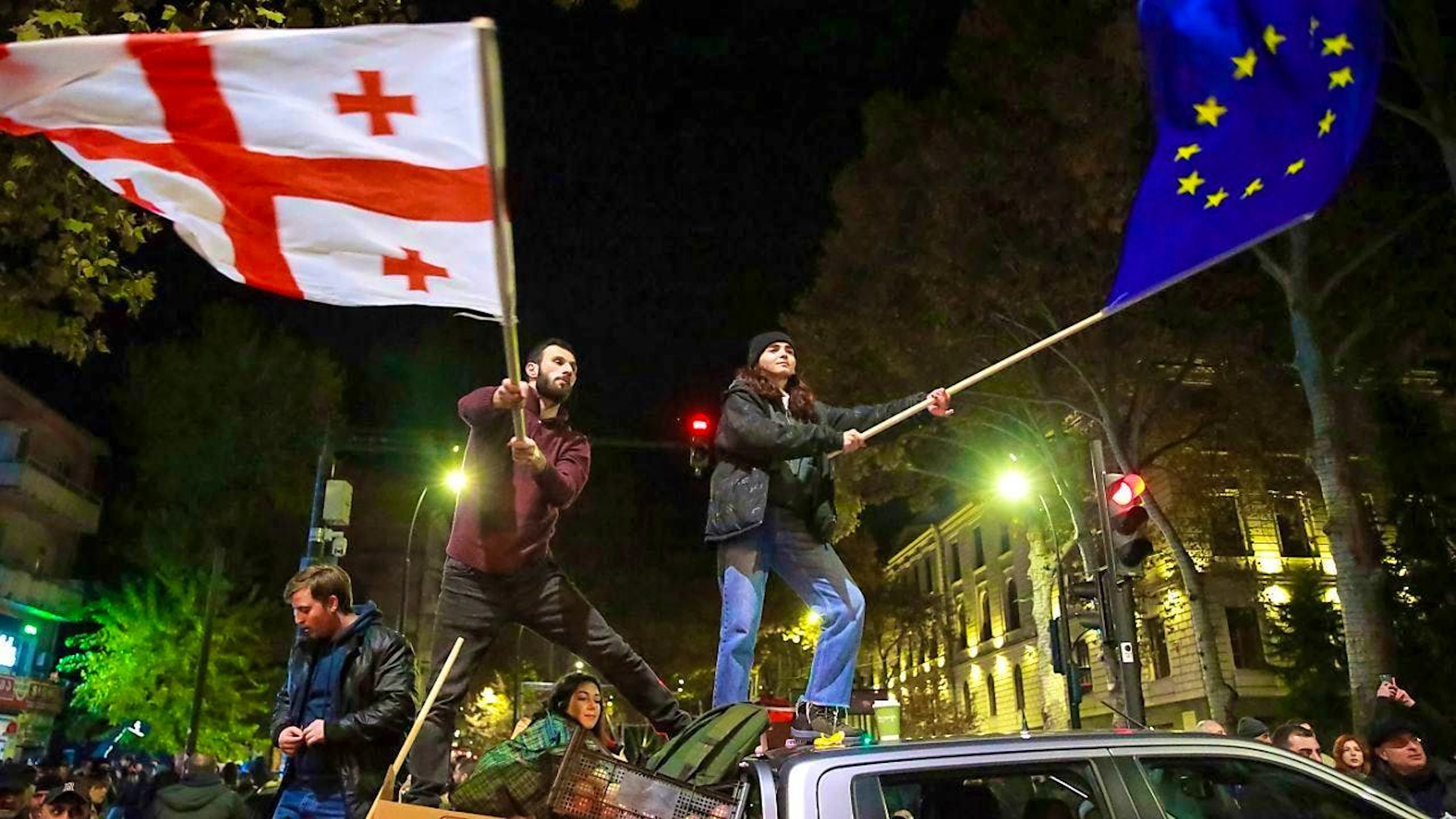 dpatopbilder - ARCHIV - Demonstrators wave a Georgian national flag and an EU flag at a rally against the results of the parliamentary elections in Georgia. Photo: Zurab Tsertsvadze/AP/dpa