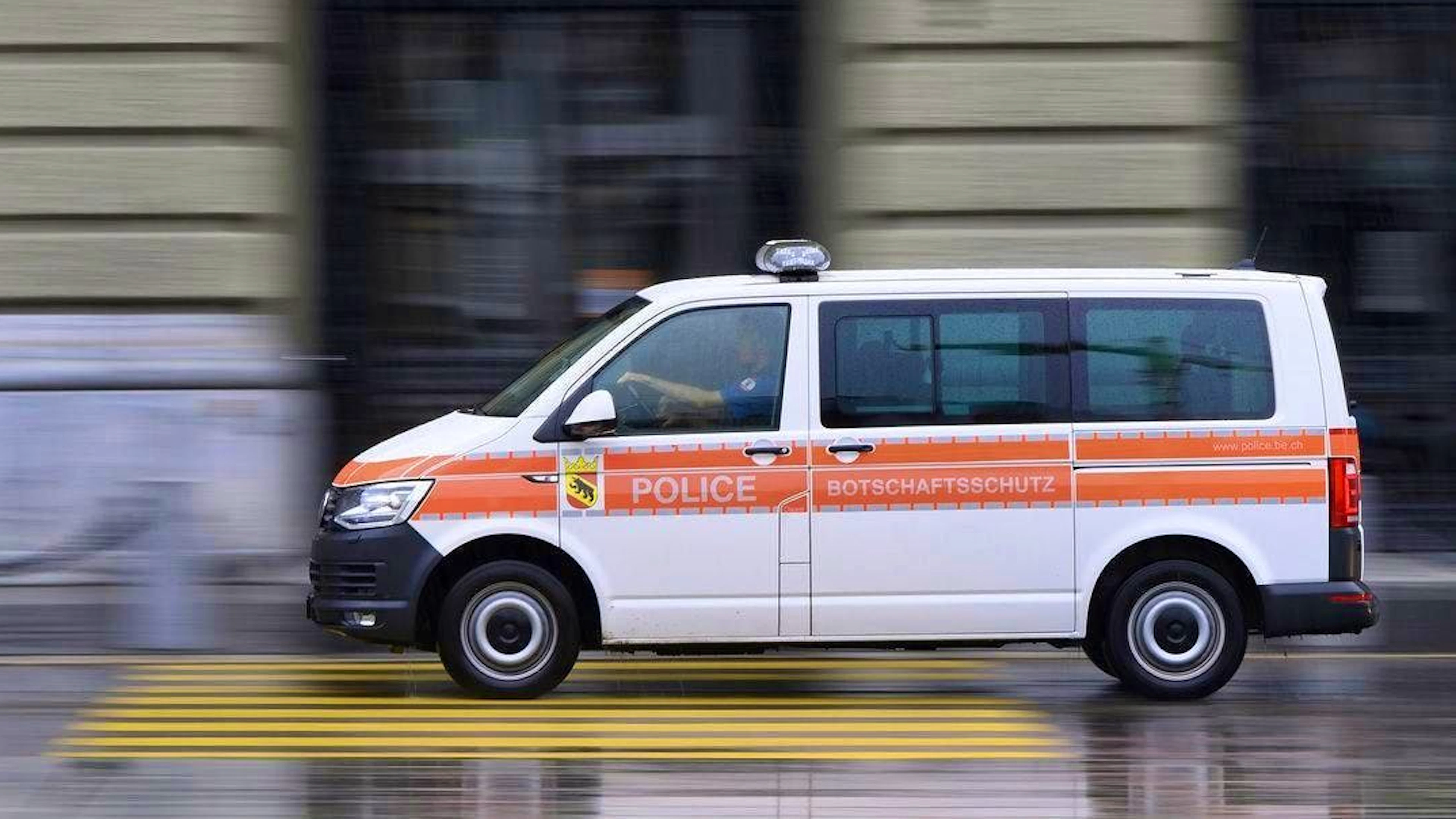 A police car drives in front of the Federal Palace on Saturday, August 7, 2021 in Bern. (KEYSTONE/Anthony Anex)