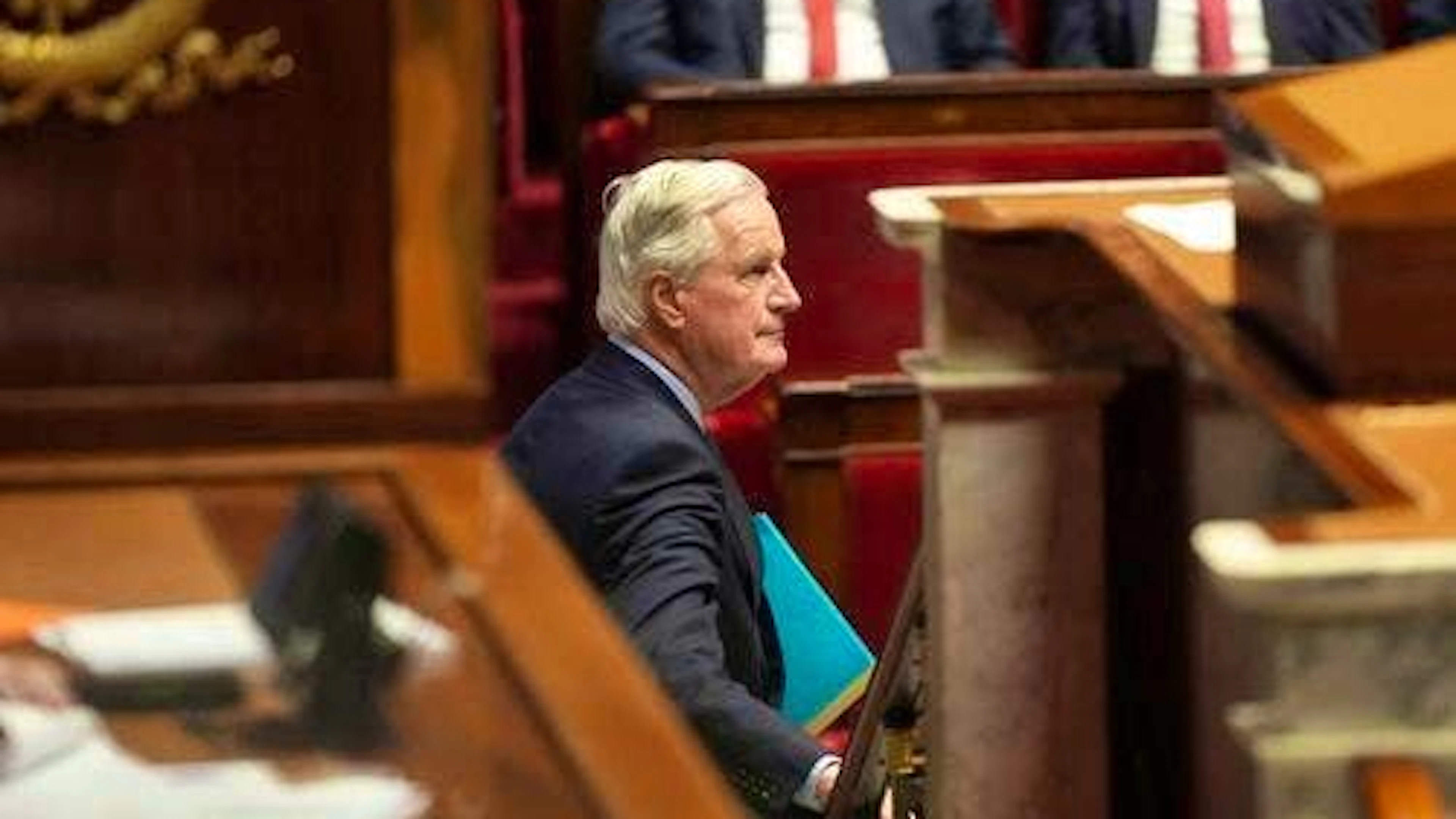 French Prime Minister Michel Barnier leaves the lectern in the National Assembly before the vote on a motion of no confidence.