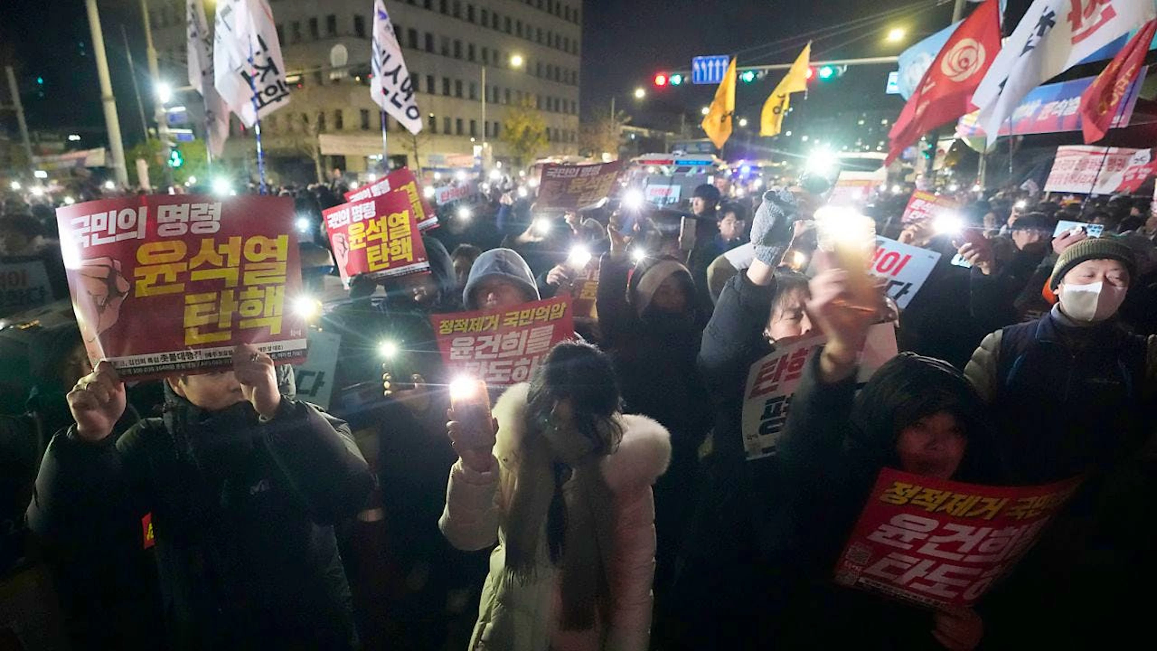 dpatopbilder - Menschen versammeln sich vor der Nationalversammlung, um den Rücktritt des südkoreanischen Präsidenten Yoon Suk Yeol zu fordern. Der Präsident Südkoreas hat das Kriegsrecht ausgerufen. In einer live ausgestrahlten Rede beschuldigte er die Opposition des Landes, mit Nordkorea zu sympathisieren. Foto: Ahn Young-joon/AP/dpa