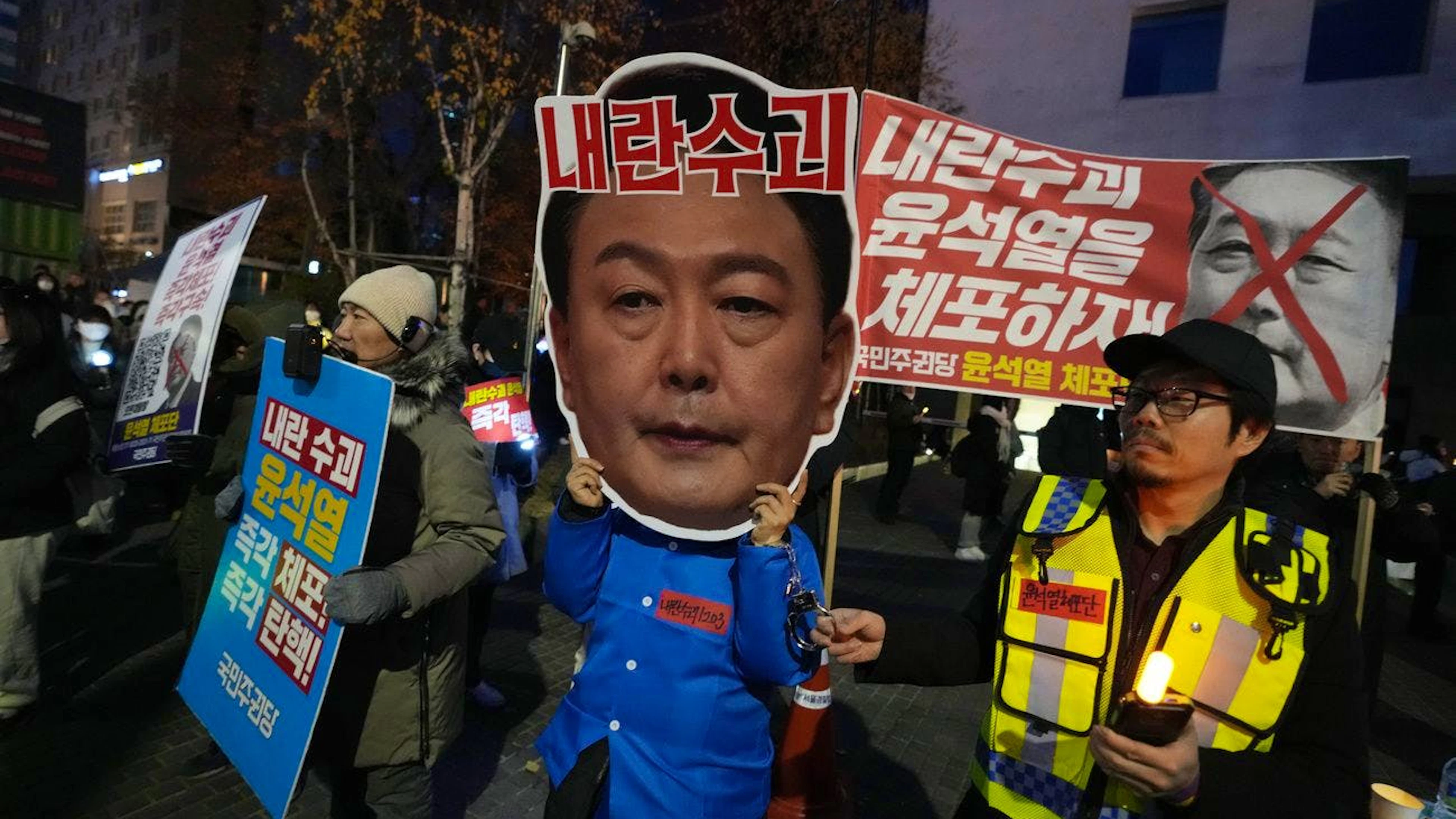 Une personne portant un masque du président sud-coréen Yoon Suk Yeol participe à un rassemblement demandant sa destitution devant l'Assemblée nationale à Séoul, en Corée du Sud, dimanche 8 décembre 2024. (AP Photo/Ahn Young-joon)