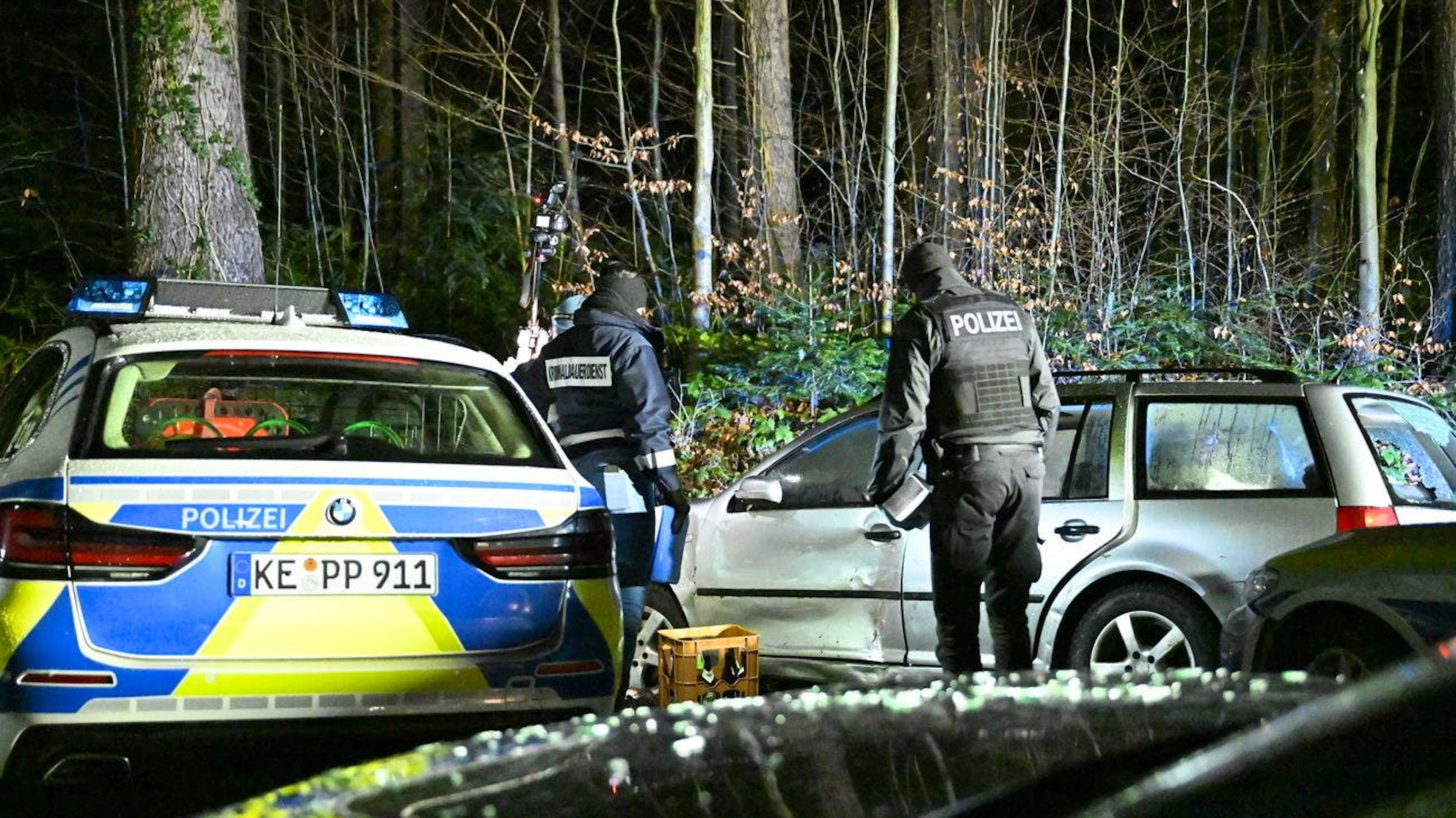 Einsatzkräfte der Polizei arbeiten an einem beschädigten Auto in einem Graben im Allgäu.