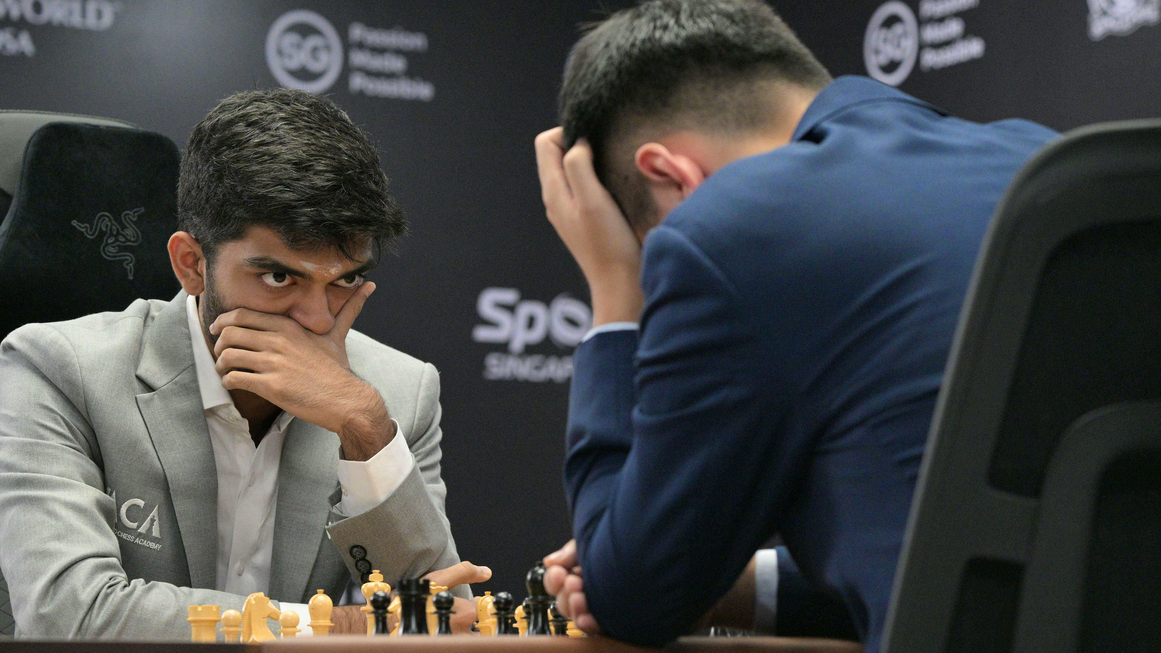 L'indiano Dommaraju Gukesh, a sinistra, guarda il suo avversario cinese Ding Liren durante la prima partita del Campionato mondiale di scacchi FIDE 2024 a Singapore.
