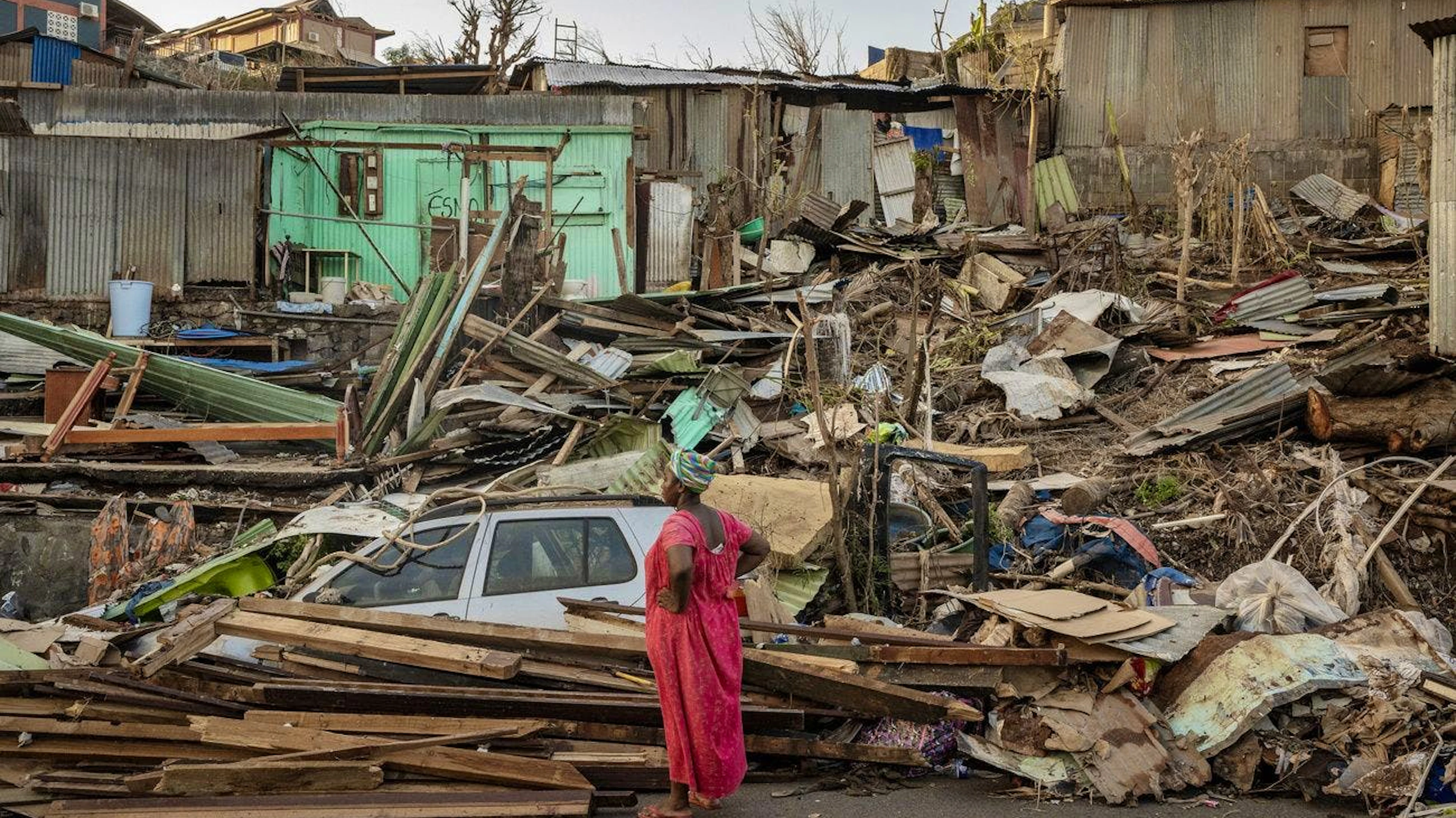 Une femme regarde une maison détruite à Mamoudzou, Mayotte, jeudi 19 décembre 2024. (AP Photo/Adrienne Surprenant)