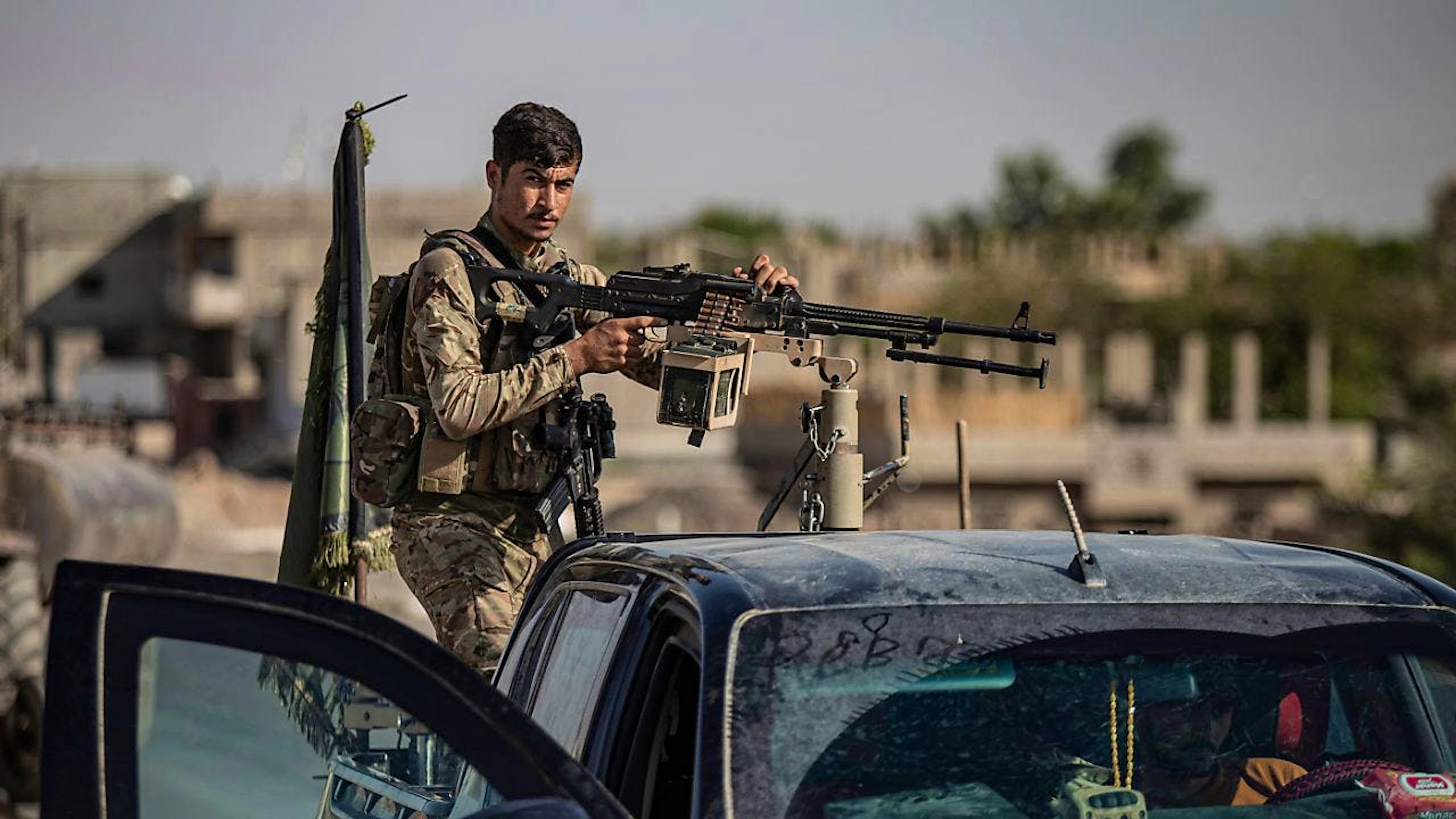 ARCHIV - Ein Kämpfer der von den USA unterstützten Syrischen Demokratischen Kräfte (SDF) steht 2023 auf einem bewaffneten Fahrzeug. Foto: Baderkhan Ahmad/AP/dpa