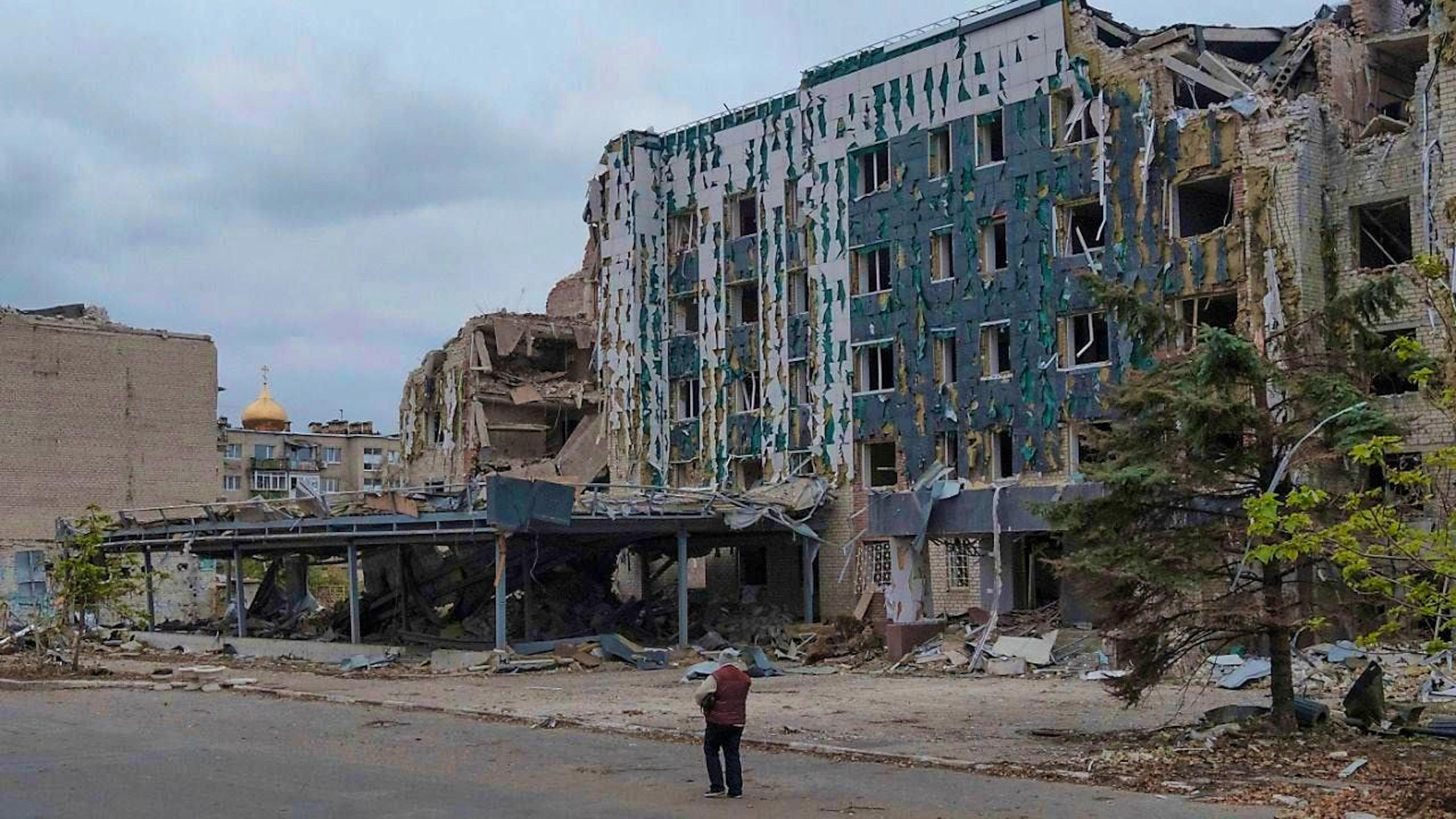 ARCHIVE - A woman walks in front of the Hotel Druzhba in Pokrovsk, which was destroyed by Russian air strikes. Photo: George Ivanchenko/AP/dpa