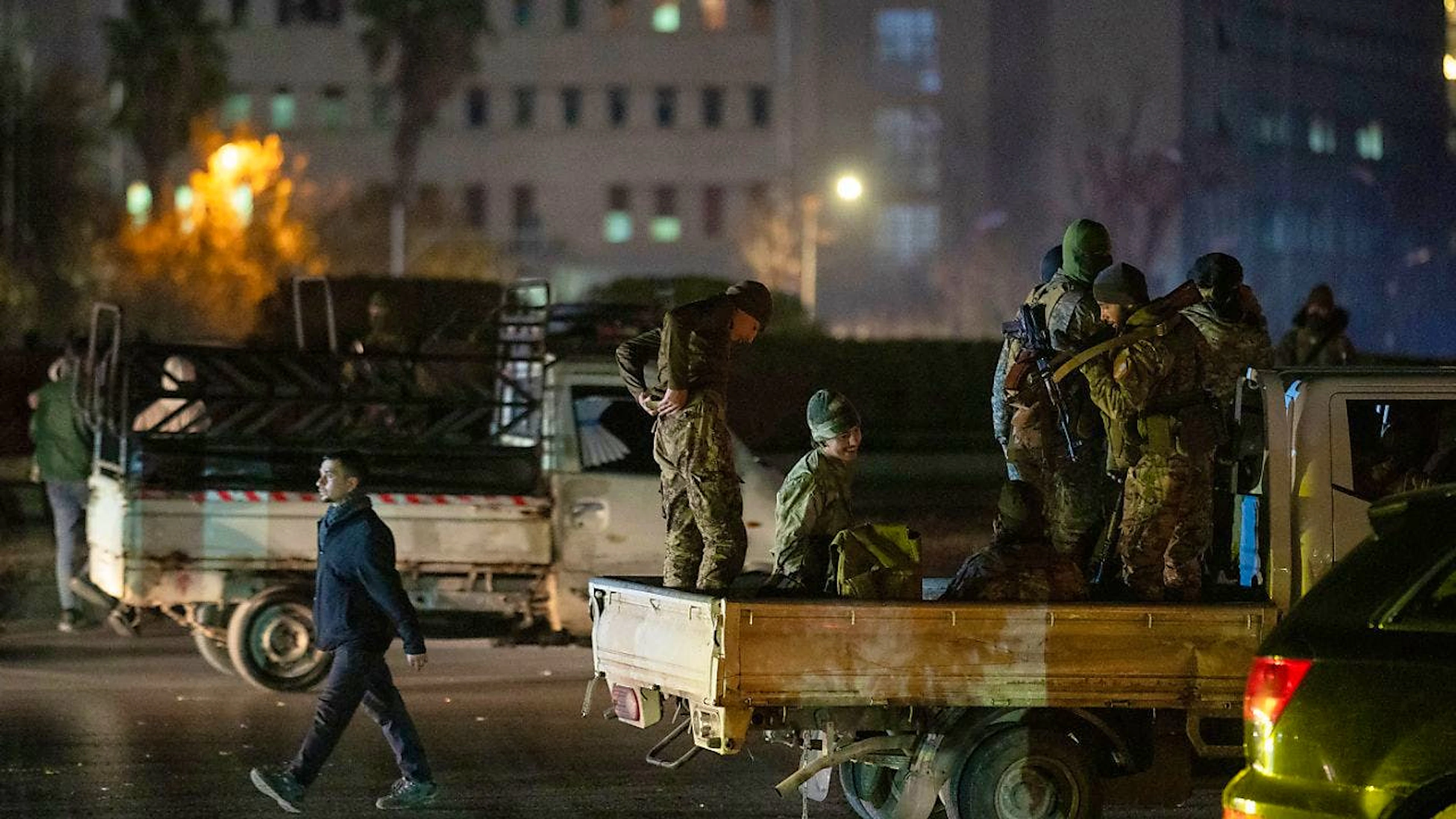 Syrische Kämpfer stehen auf einem Fahrzeug, das auf einer Straße am zentralen Platz in Damaskus parkt. Foto: Leo Correa/AP/dpa