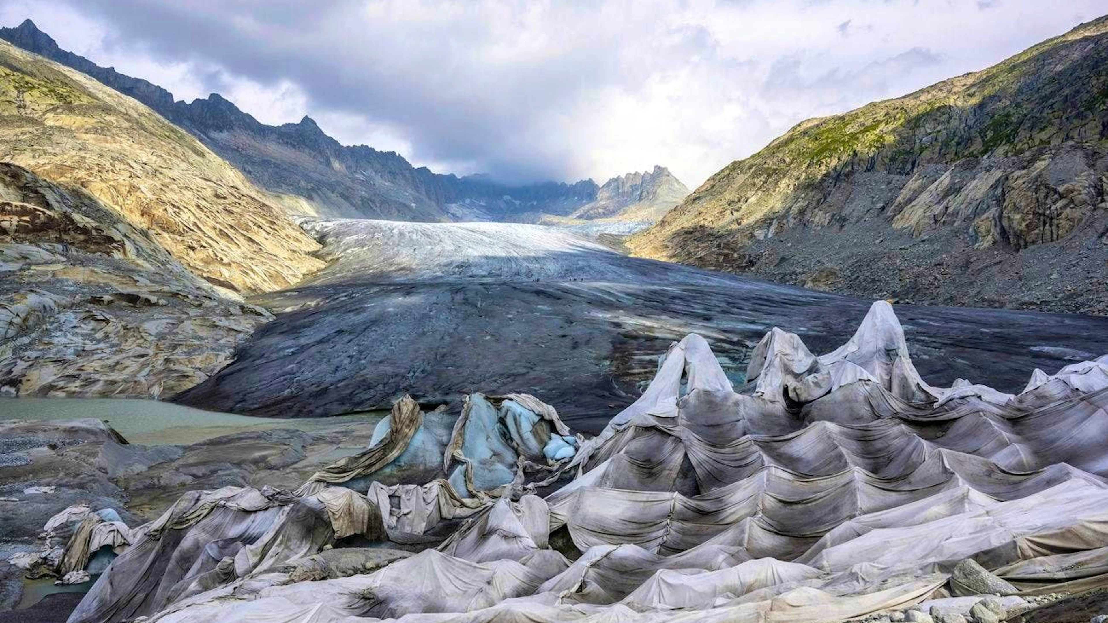 Climate change is massively affecting the Swiss glaciers and they are retreating. Here, the Rhone glacier is being protected from the sun with cloths to prevent it from melting even faster
