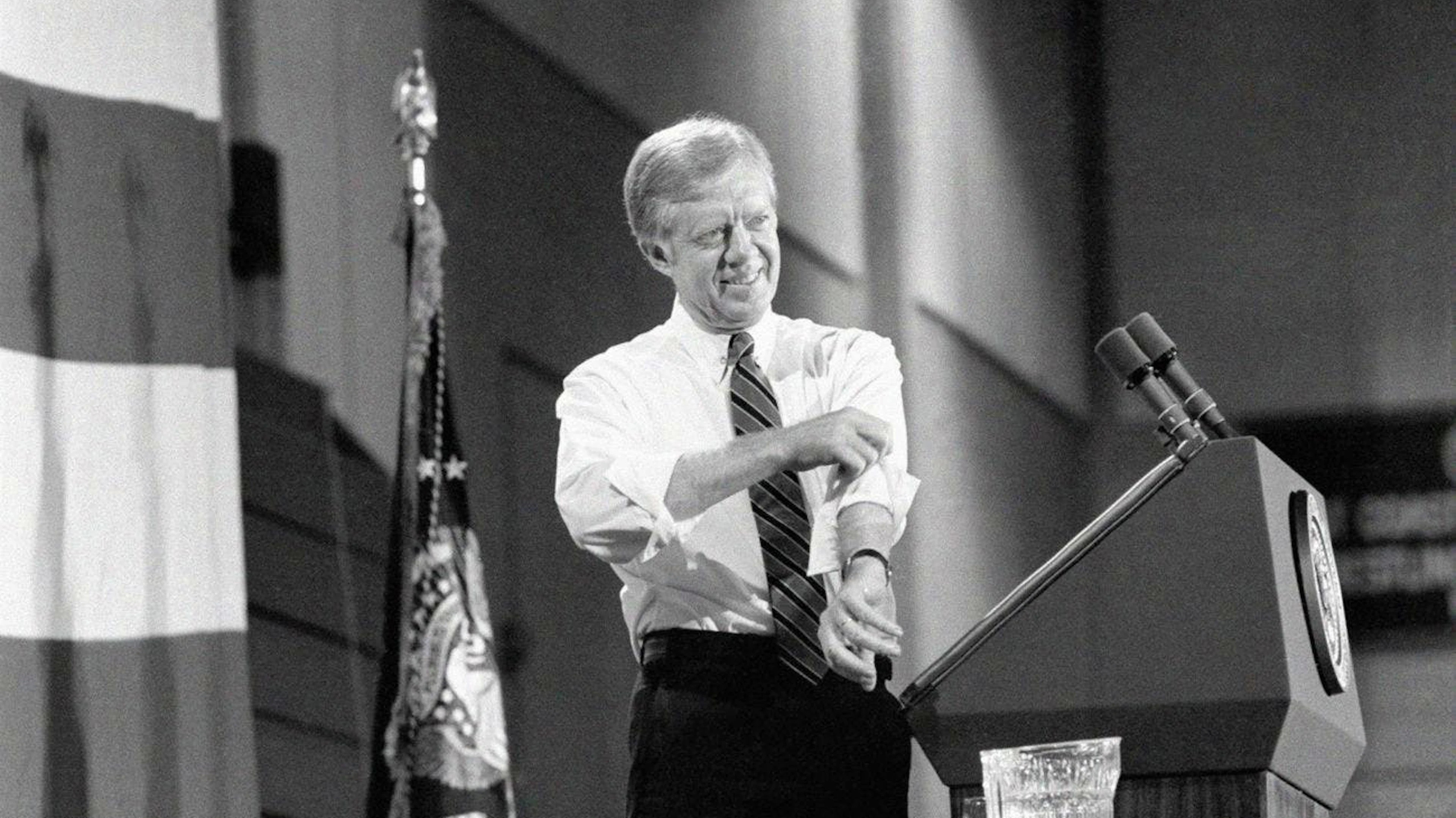 Le président américain Jimmy Carter retrousse ses manches pendant son discours de campagne lors d'une réunion à l'université Hofstra à Hempstead, New York, le jeudi 16 octobre 1980. Carter a déclaré que l'augmentation des prix de l'essence était le résultat des actions de l'OPEP qui échappaient au contrôle du gouvernement des États-Unis. (AP Photo/Wilson)