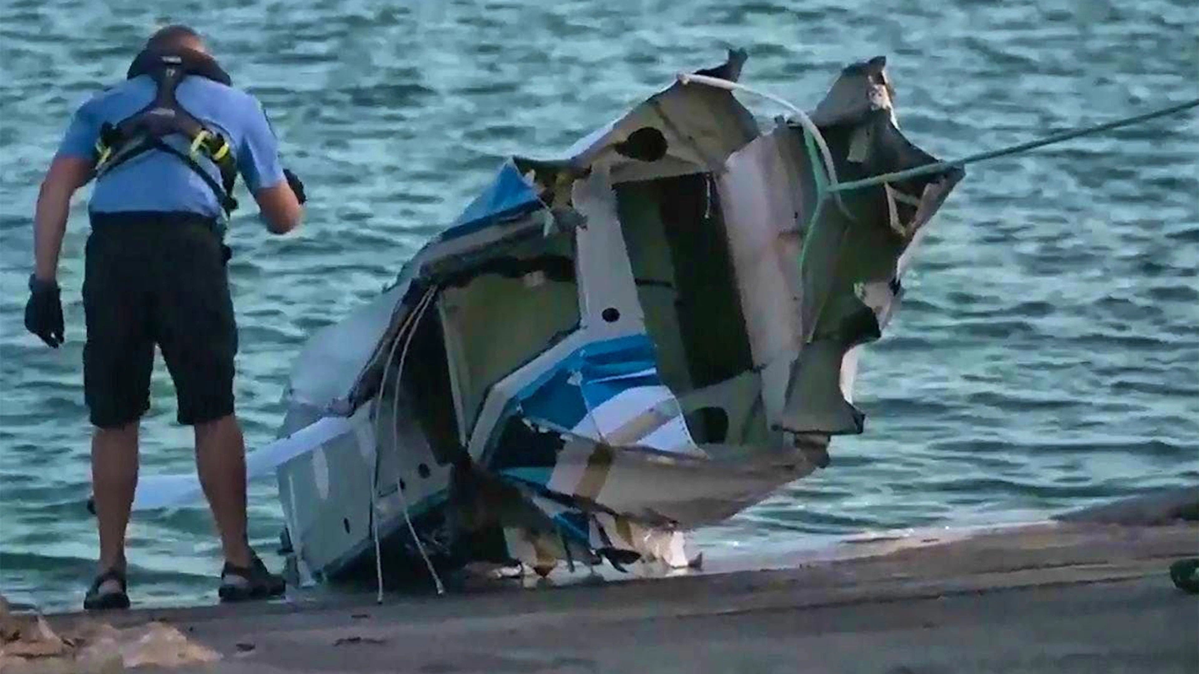 Parts of the wreckage of the crashed seaplane are pulled ashore.