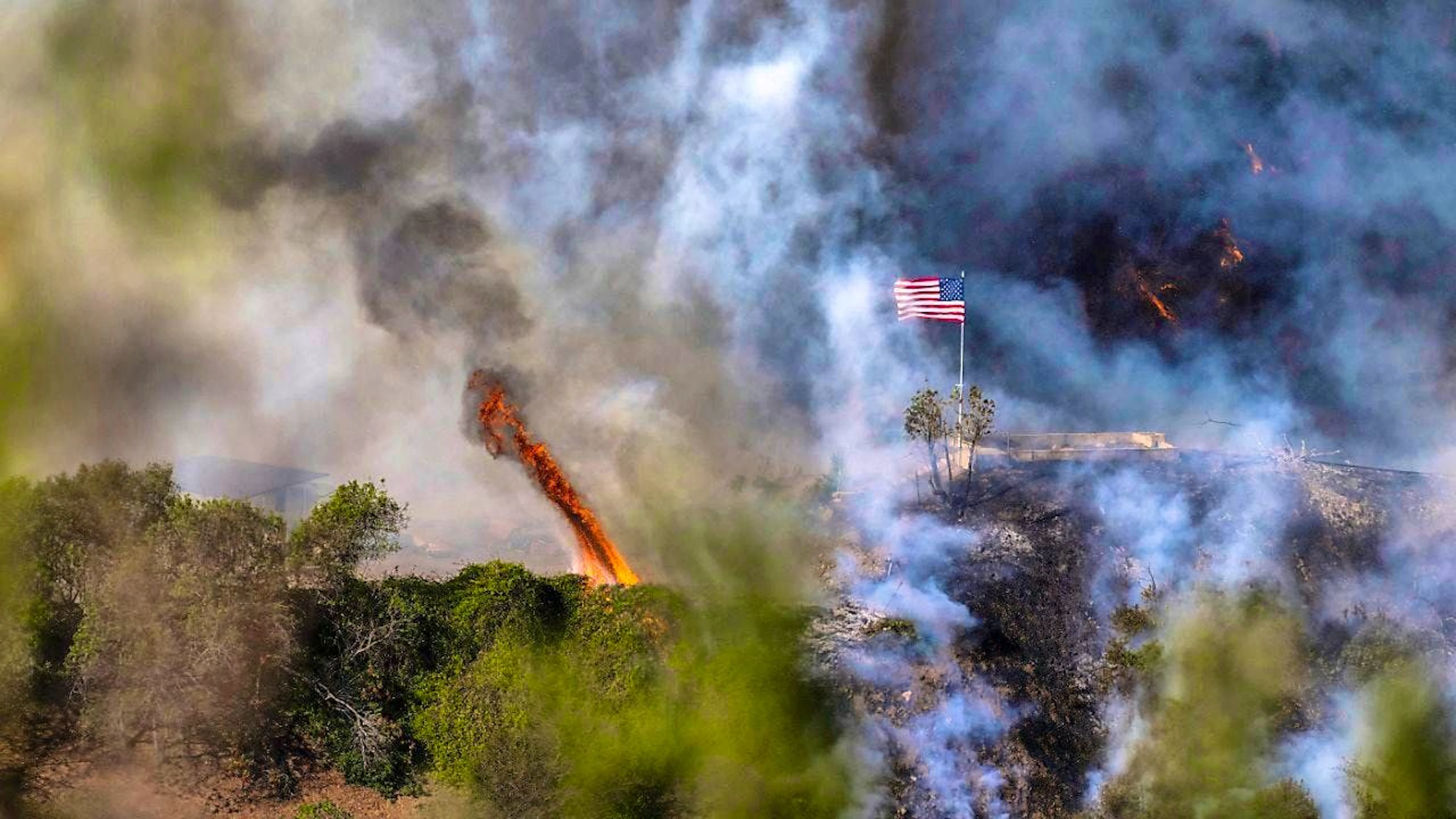dpatopbilder - An American flag flies over a section of Mandeville Canyon that was destroyed by the Palisades Fire. Photo: Mark Edward Harris/ZUMA Press Wire/dpa