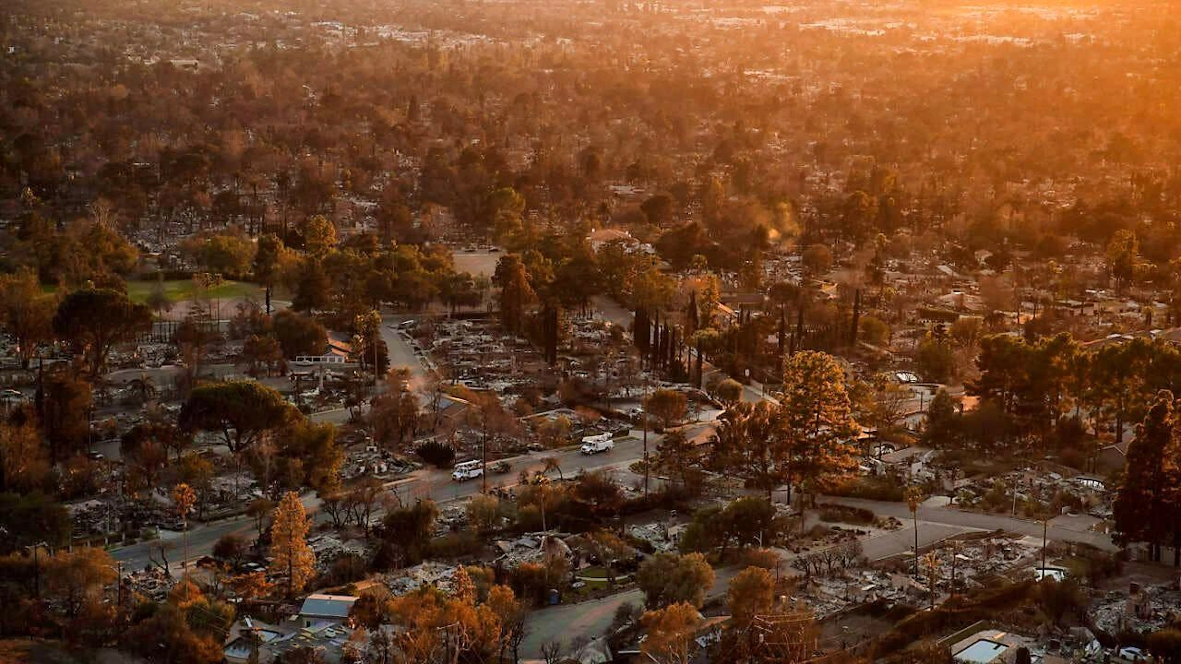 Trucks drive through a neighborhood destroyed by the Eaton Fire. Photo: John Locher/AP/dpa