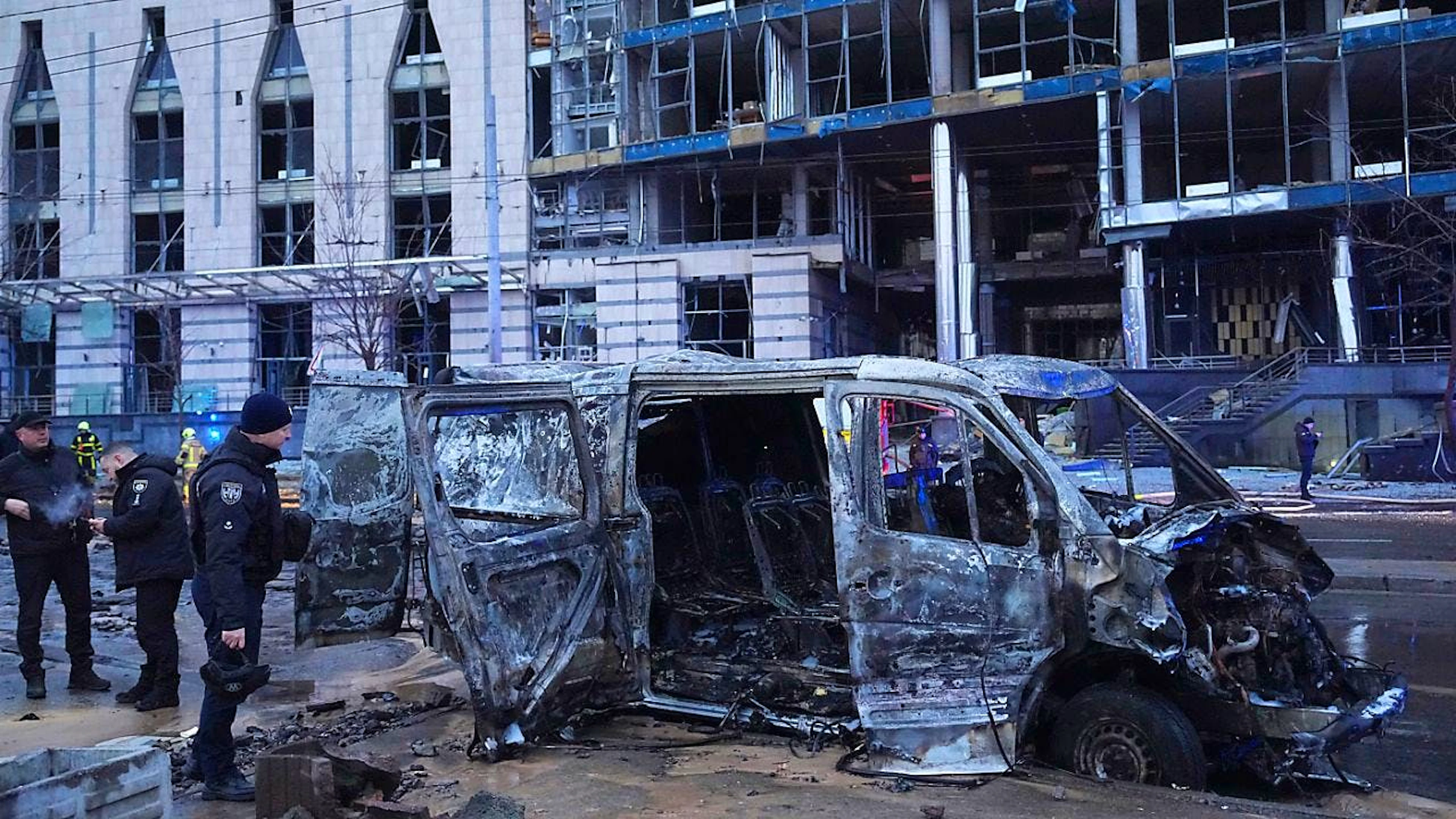Ein zerstörtes Auto ist zu sehen, während Polizisten vor einem beschädigten Gebäude nach einem russischen Raketenangriff arbeiten. Foto: Efrem Lukatsky/AP/dpa