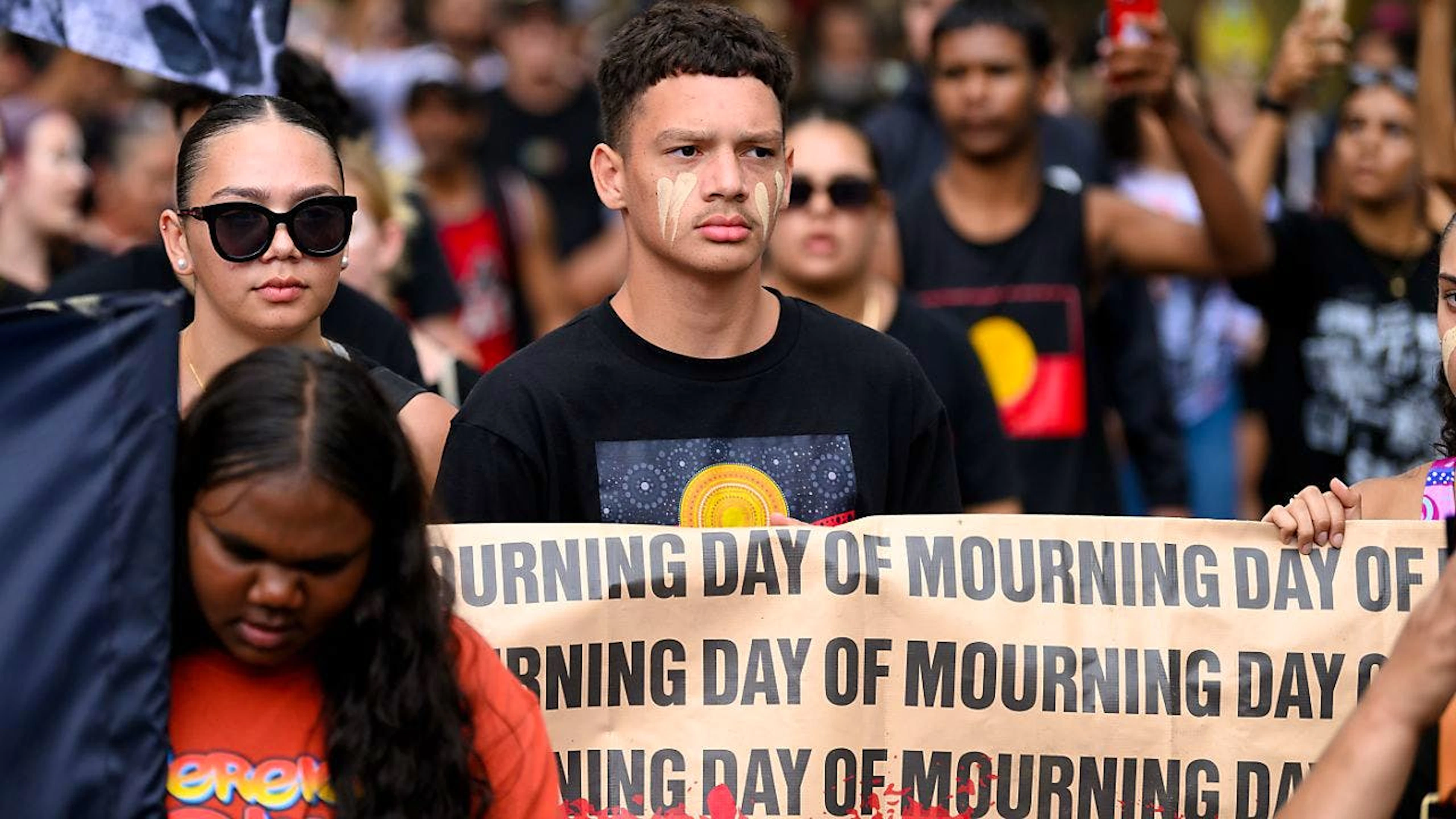 "Day of Mourning" (Tag der Trauer) steht auf einem Banner, das von Teilnehmern am umstrittenen Feiertag "Australia Day", der von Gegenern "Invasion Day" genannt wird, auf einer Kundgebung in Sydney gezeigt wird. Foto: Steven Markham/AAP/dpa