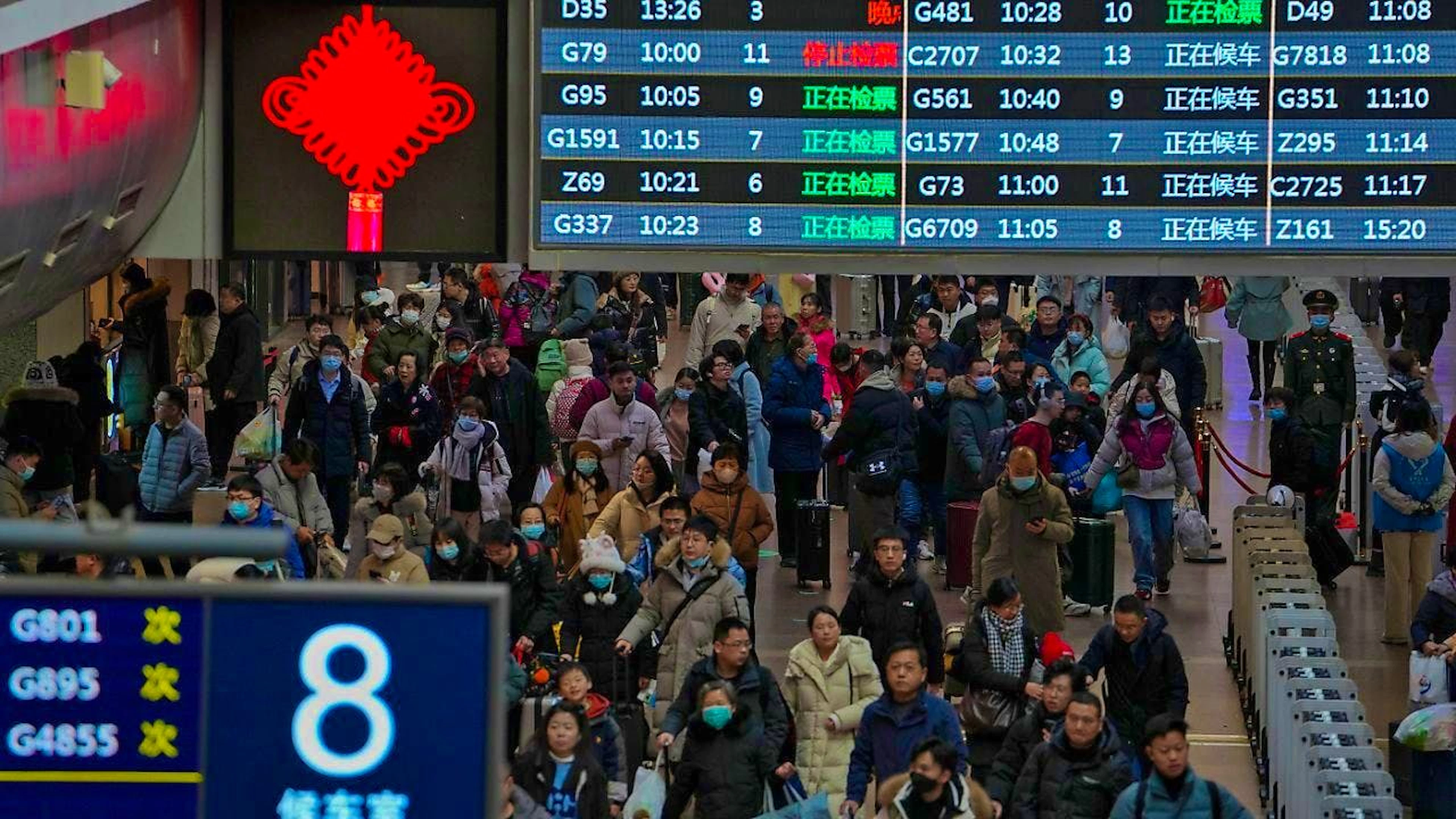 ARCHIVE - Travelers walk under a train departure board to catch their trains. Many families celebrate the Chinese New Year together. Millions of people often travel to their hometowns for the occasion. Photo: Andy Wong/AP/dpa/Archive image