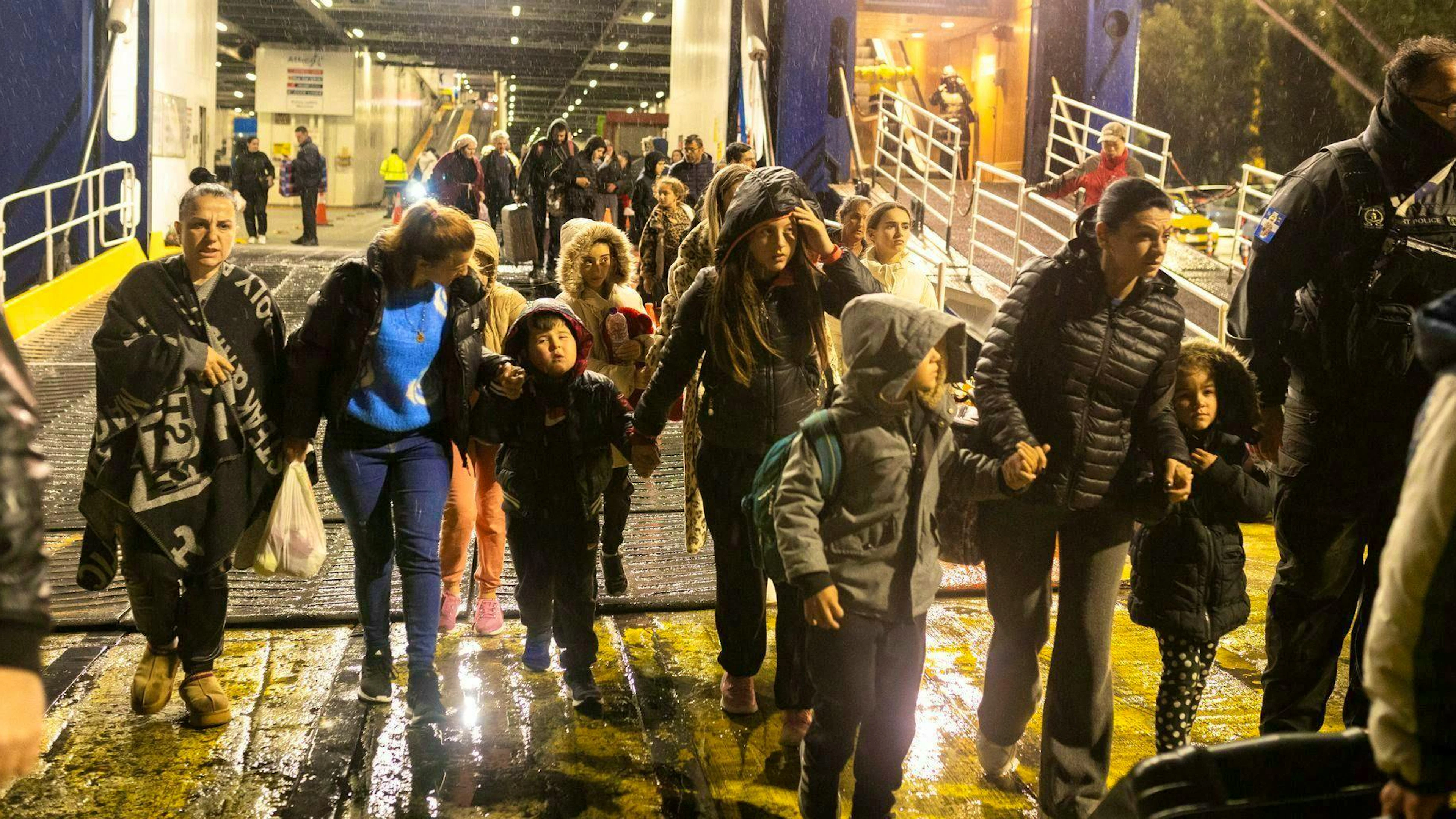 People disembark from a ferry in the port of Piraeus on which they left the island of Santorini.